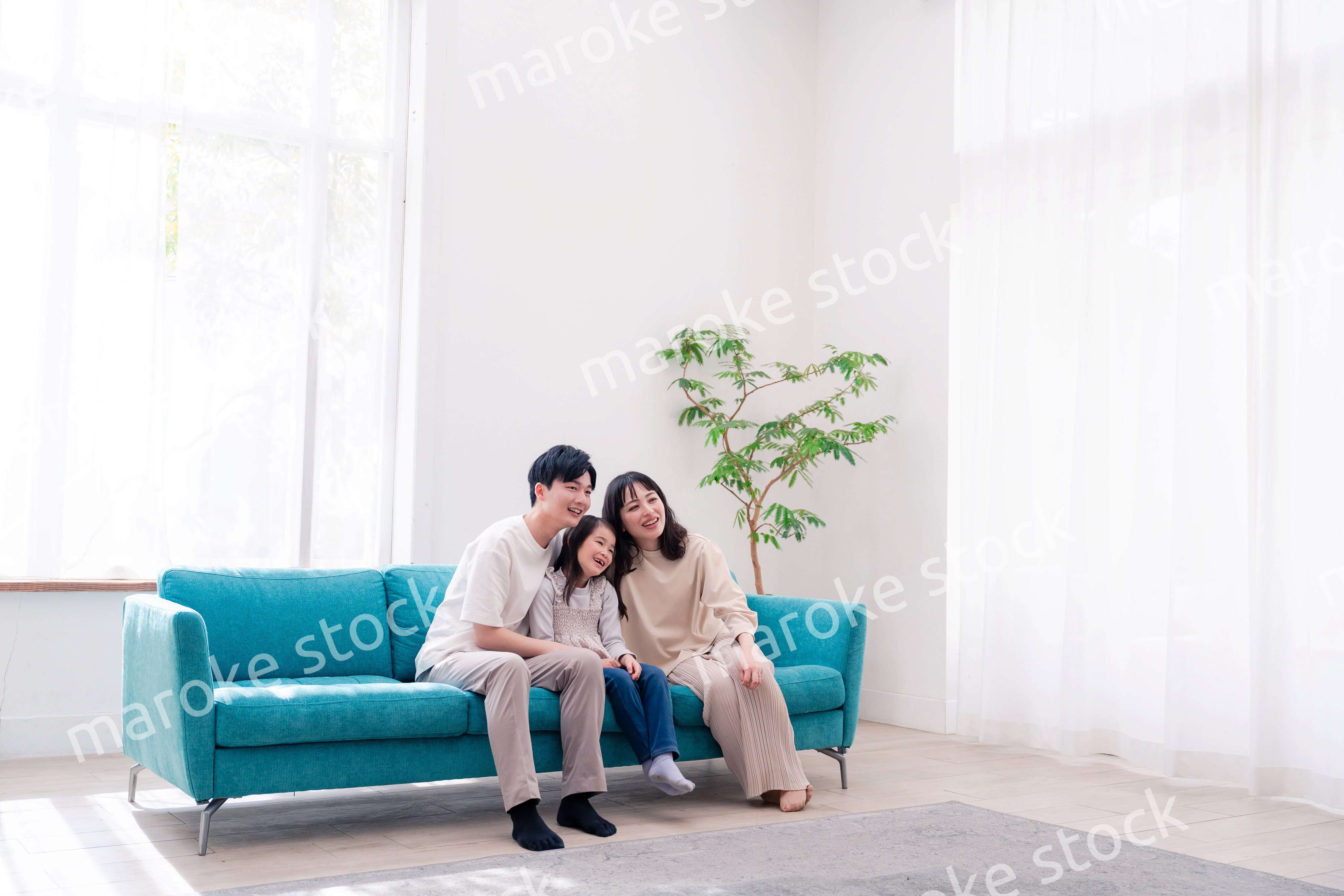 リビングでみんなでテレビを見るファミリー