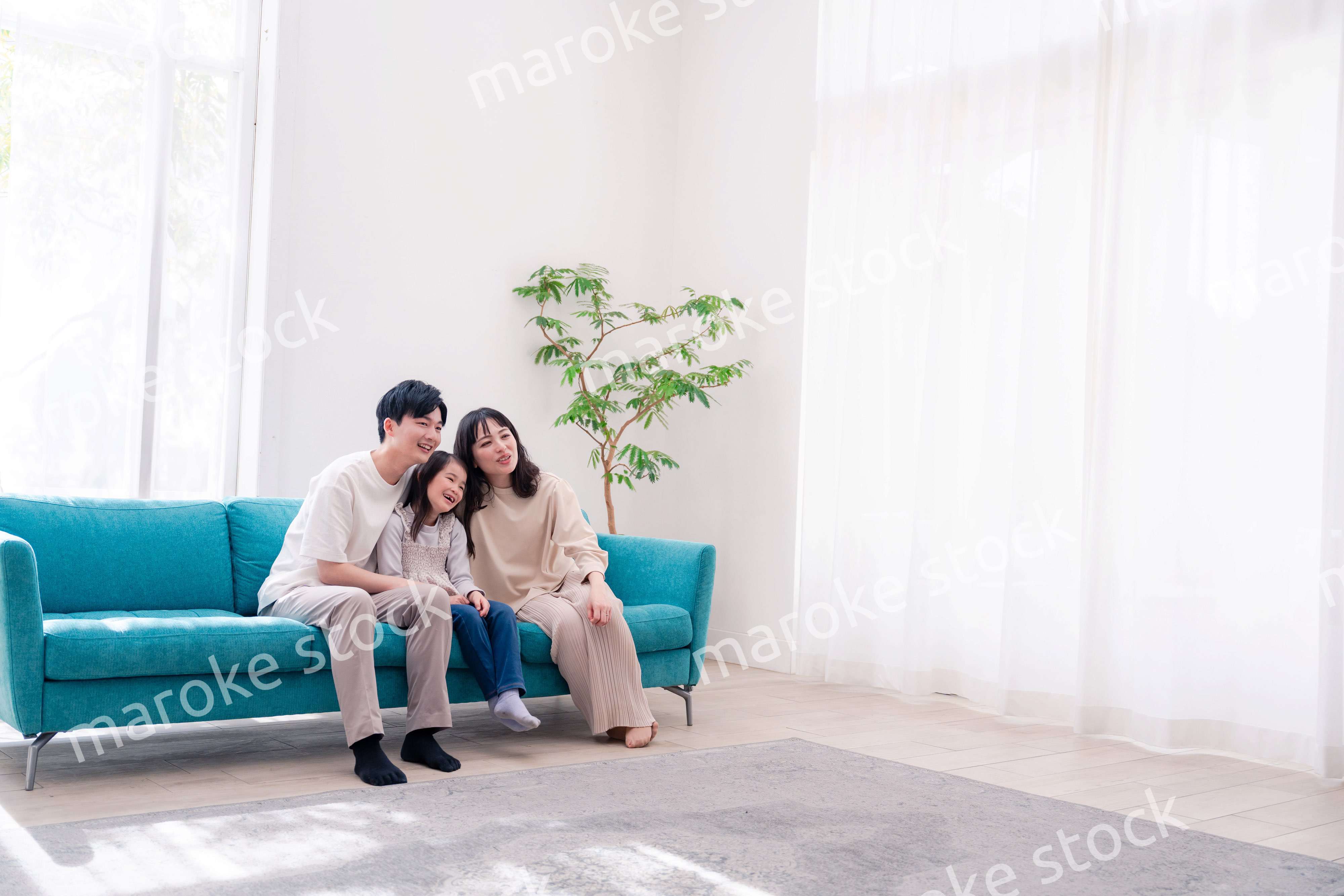 リビングでみんなでテレビを見るファミリー