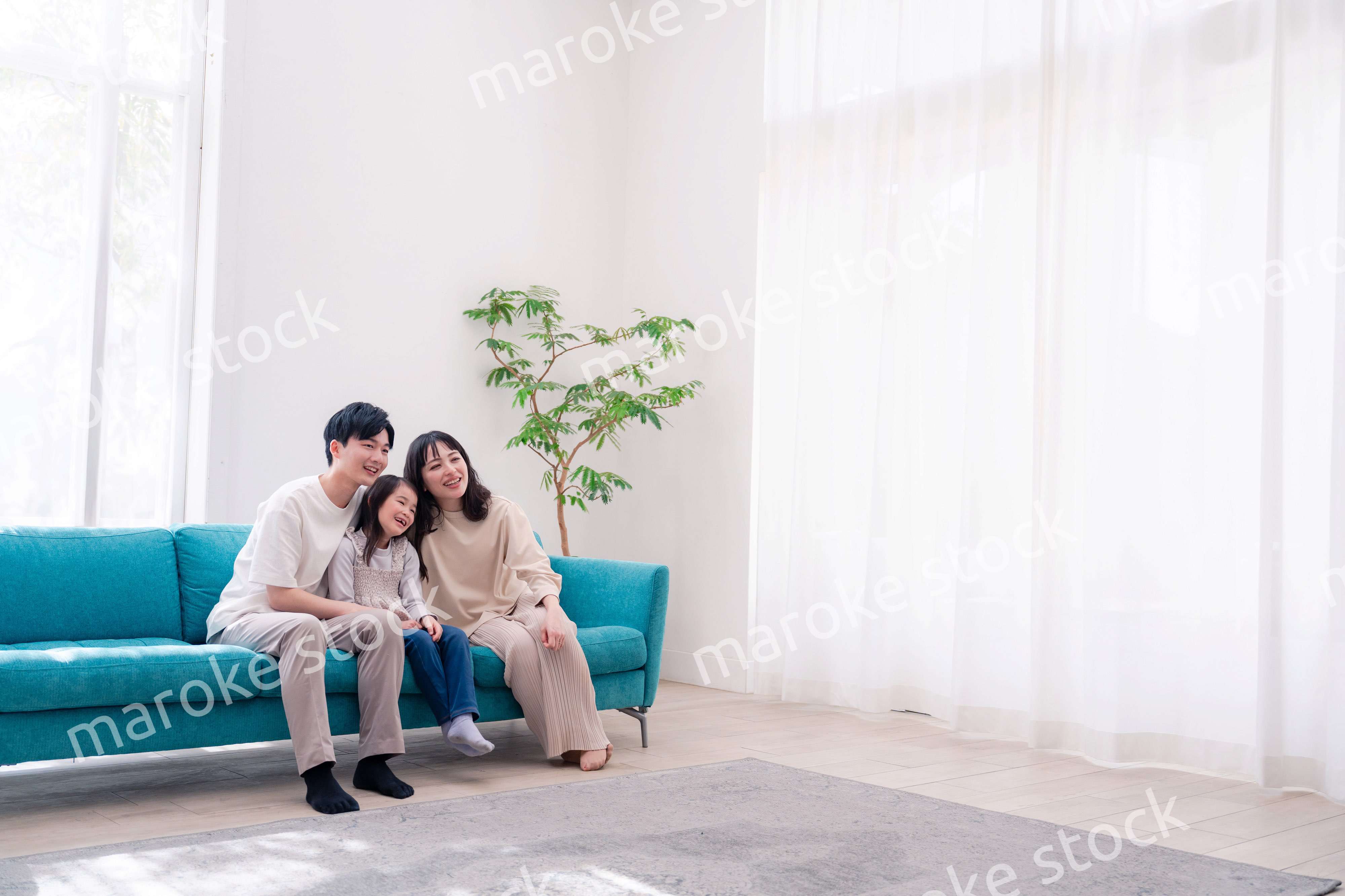 リビングでみんなでテレビを見るファミリー