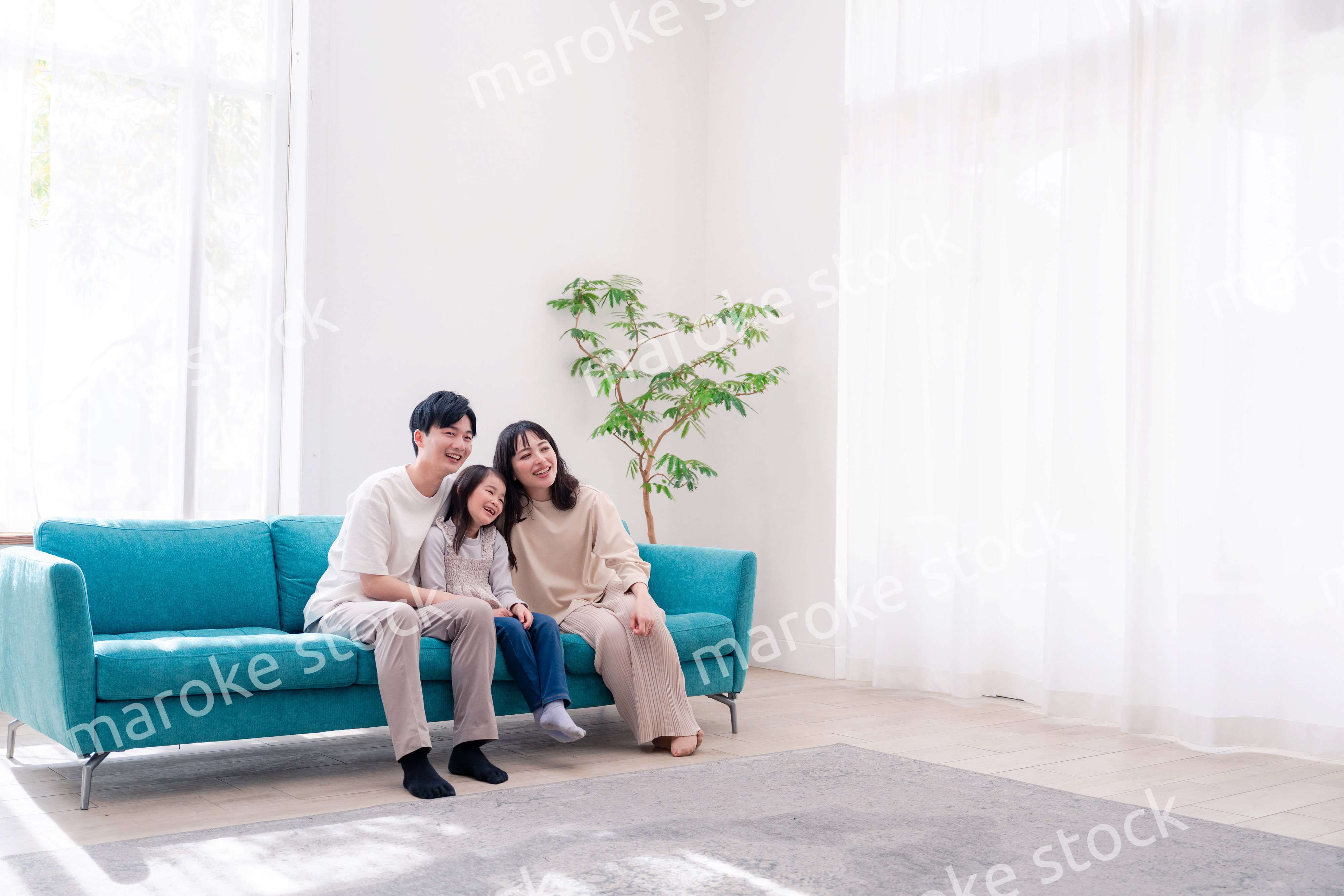 リビングでみんなでテレビを見るファミリー