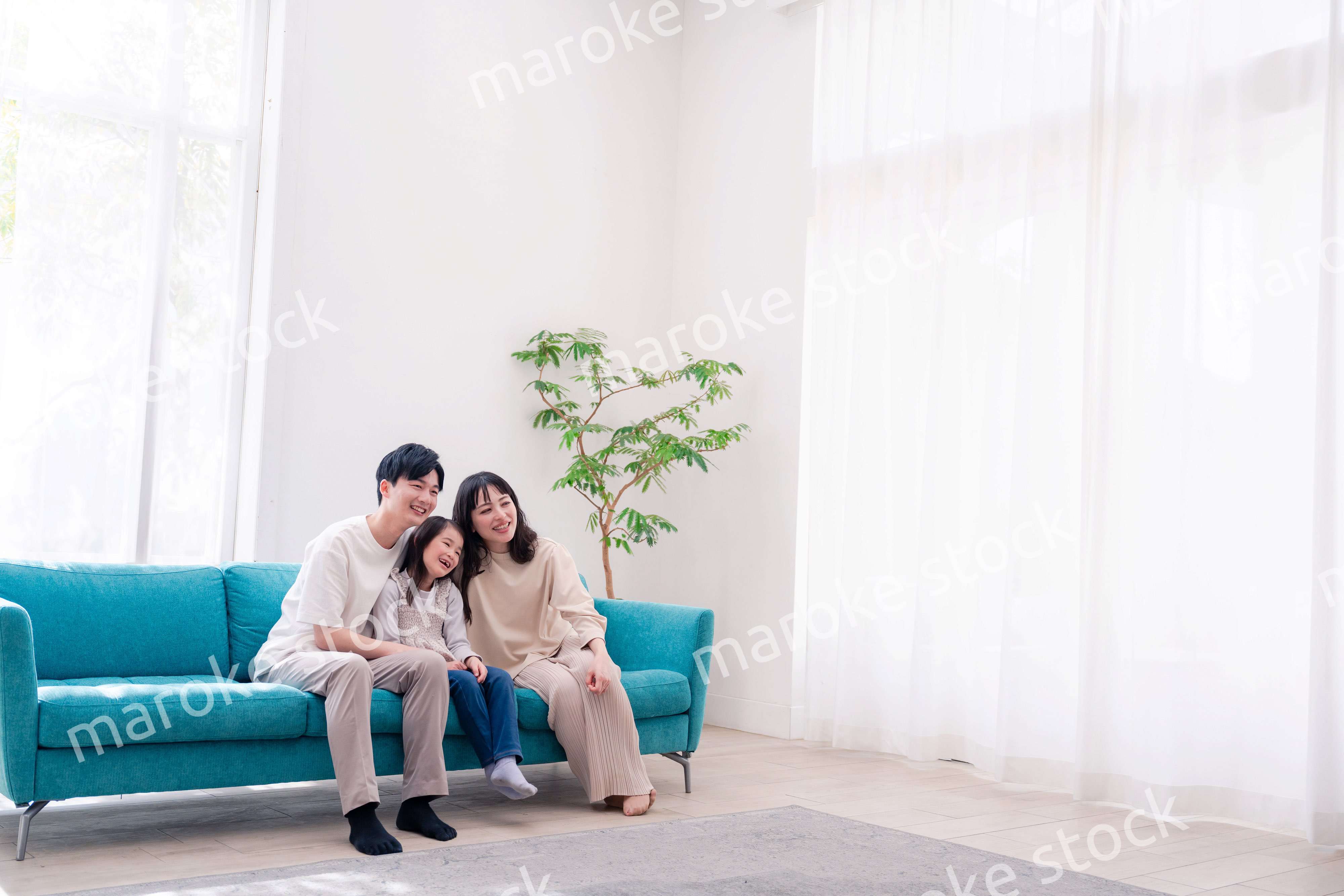 リビングでみんなでテレビを見るファミリー