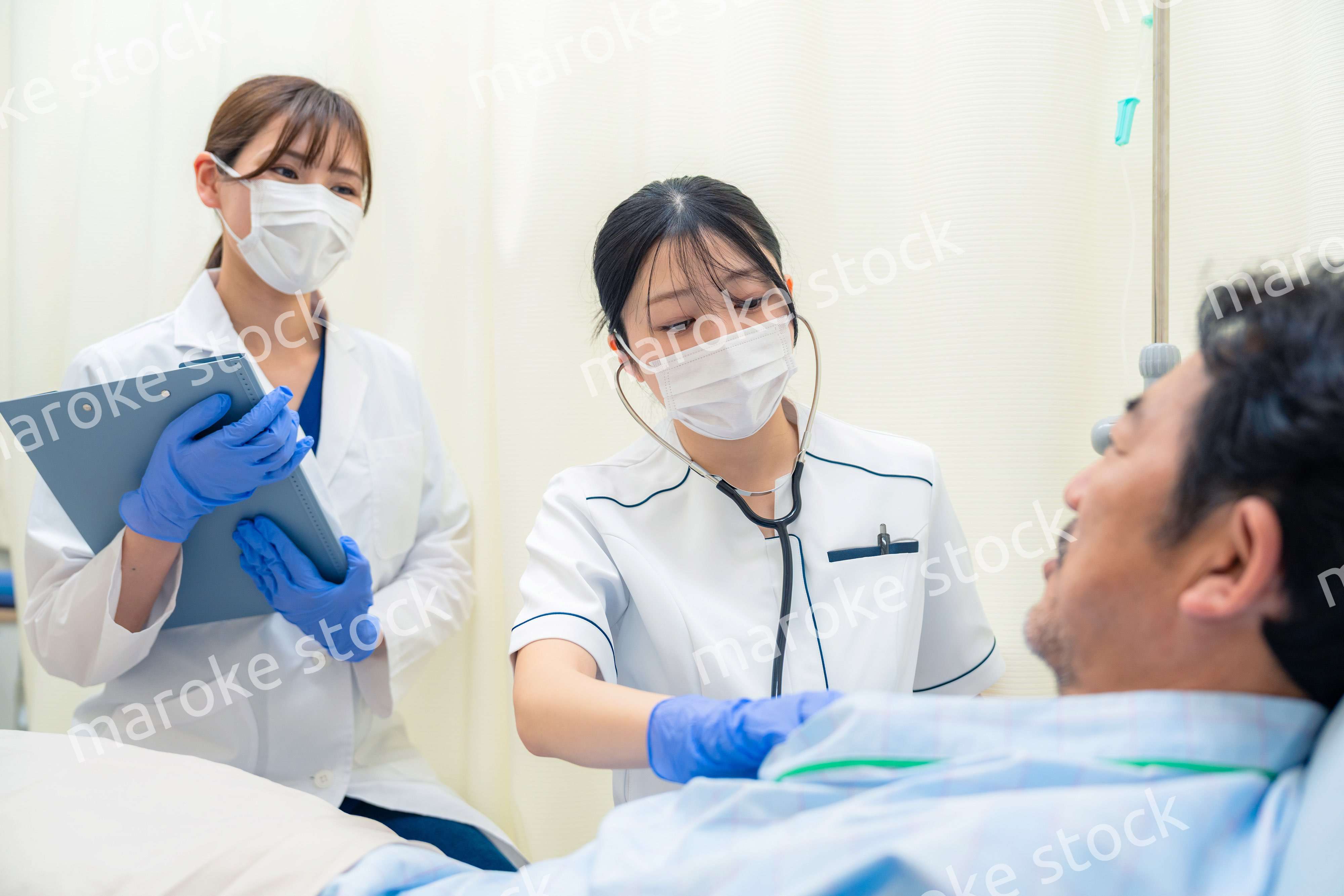 病棟で入院患者のバイタルチェックをする看護師の女性