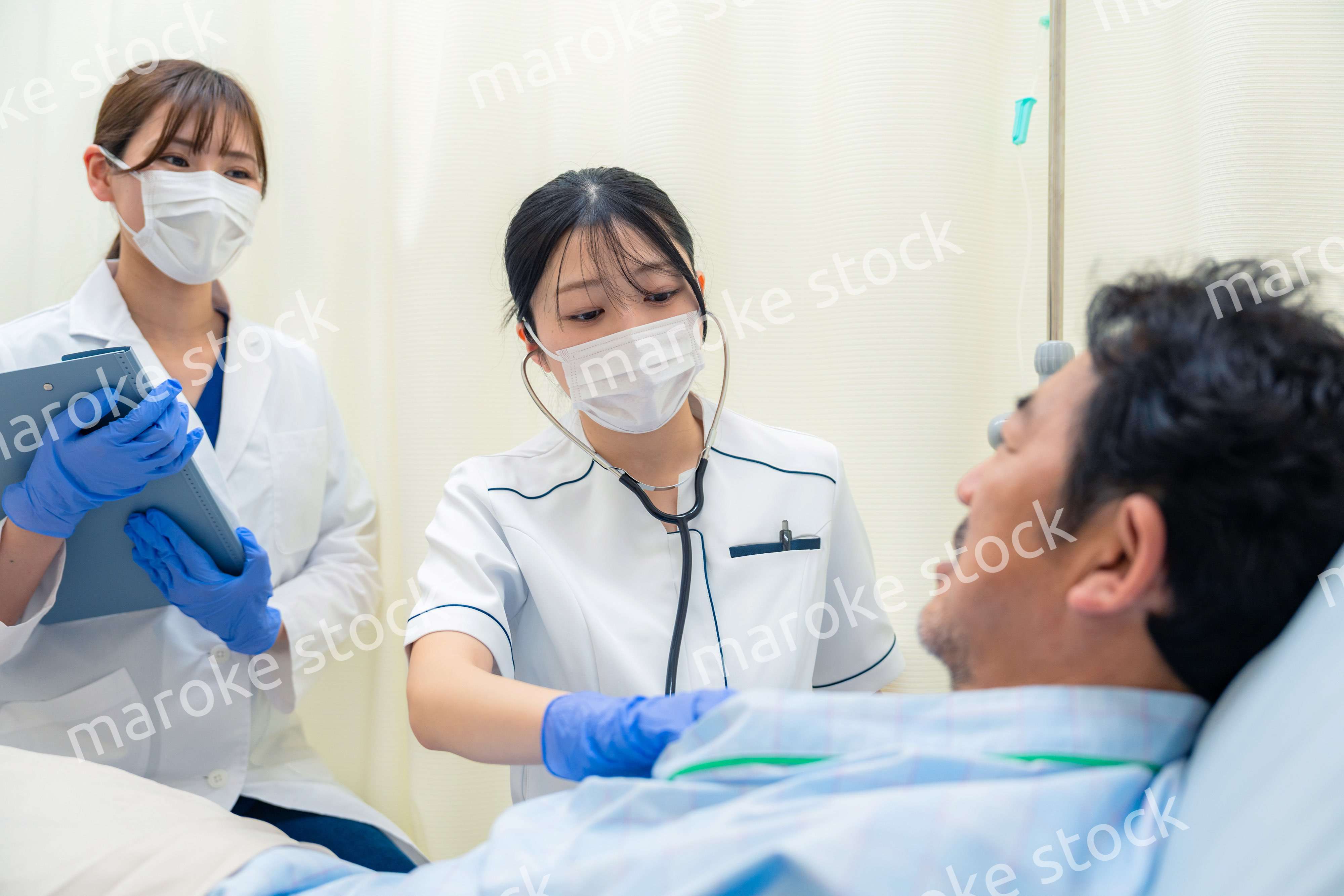 病棟で入院患者のバイタルチェックをする看護師の女性