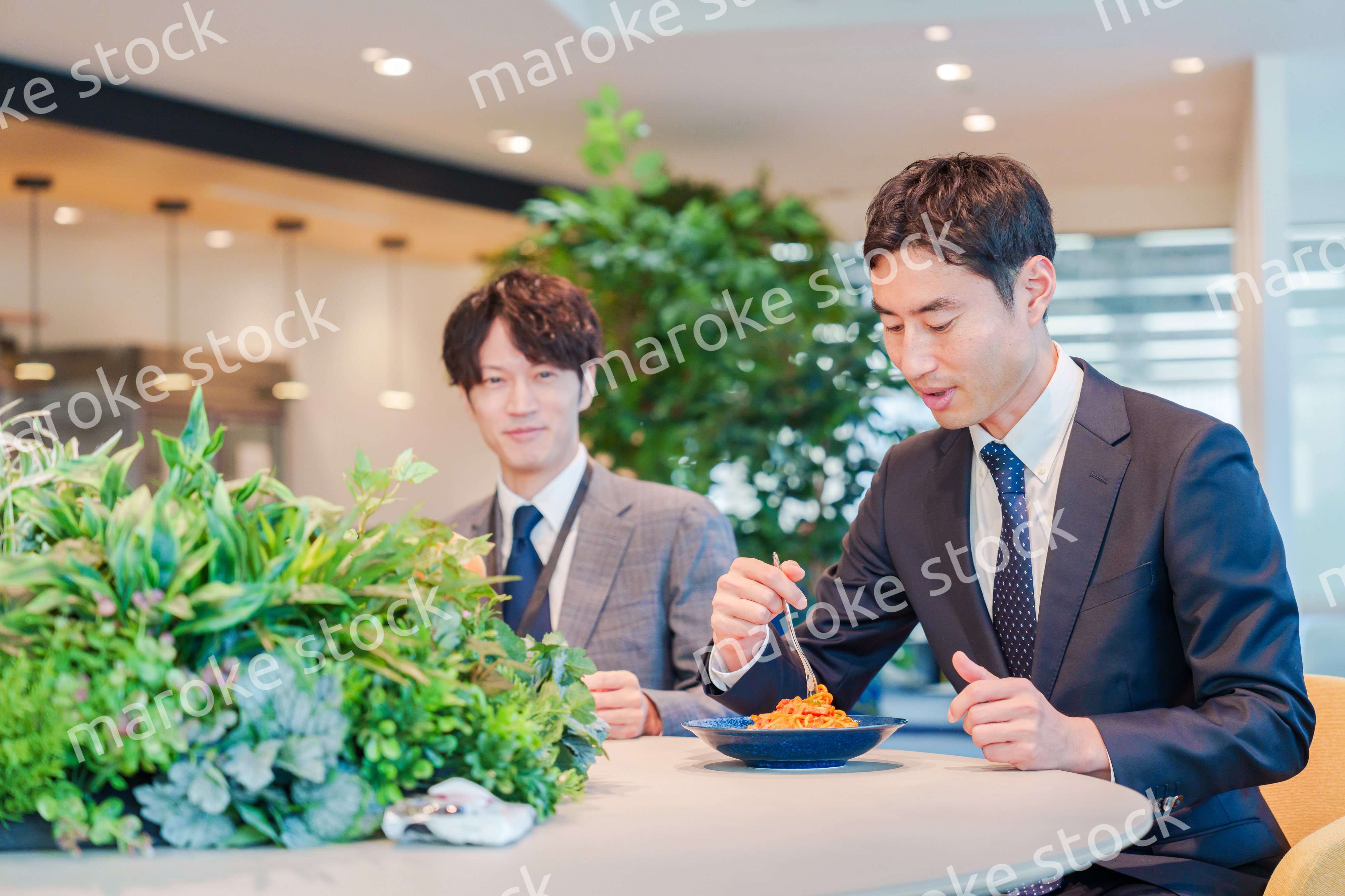 おしゃれなオフィスのカフェテリアでランチをするビジネスマン