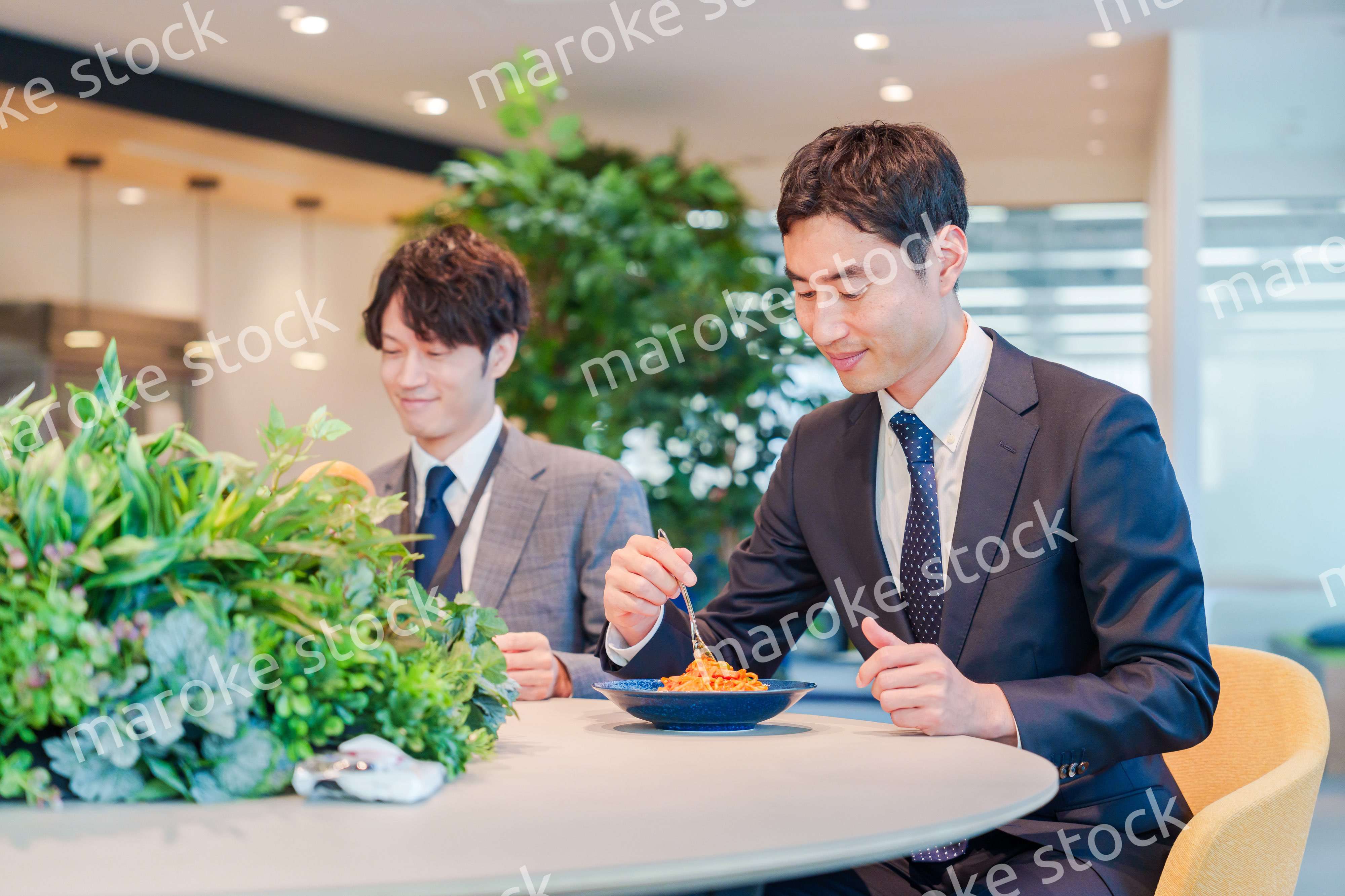 おしゃれなオフィスのカフェテリアでランチをするビジネスマン