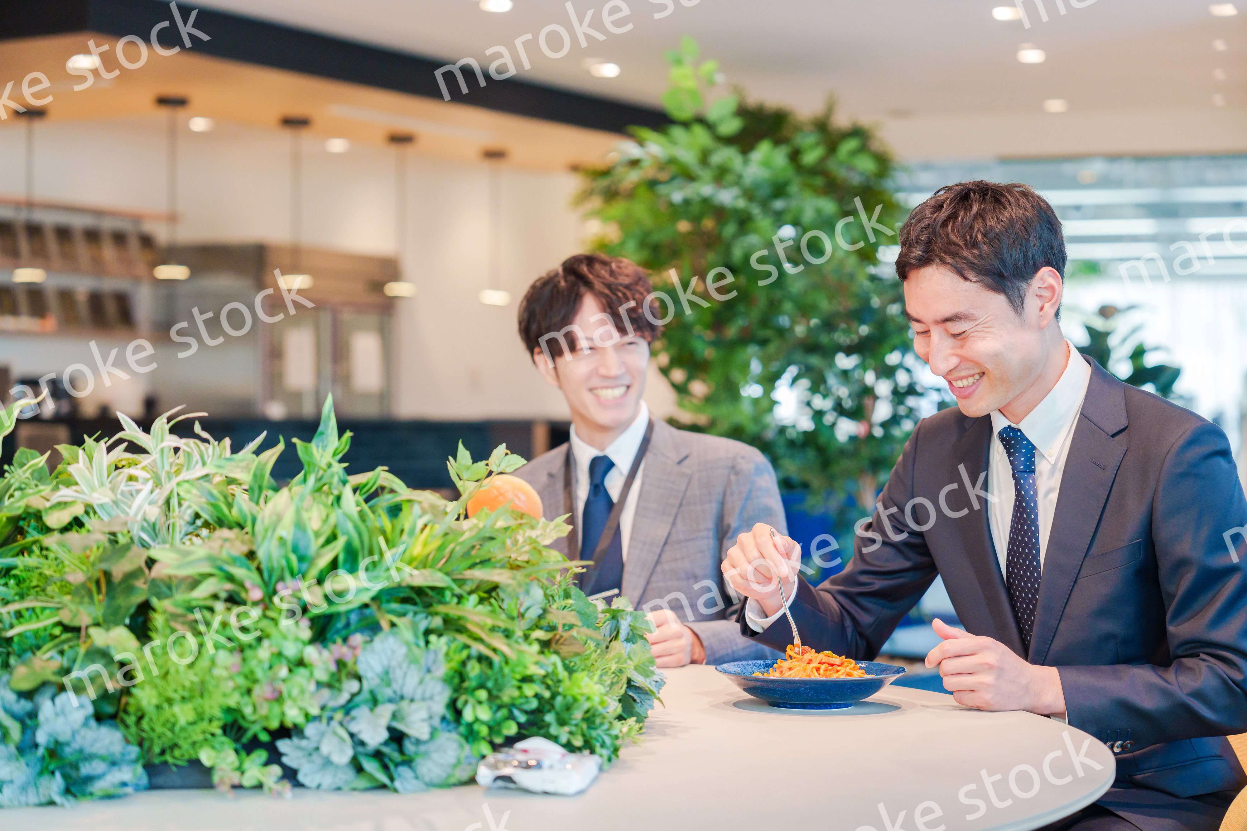 おしゃれなオフィスのカフェテリアでランチをするビジネスマン