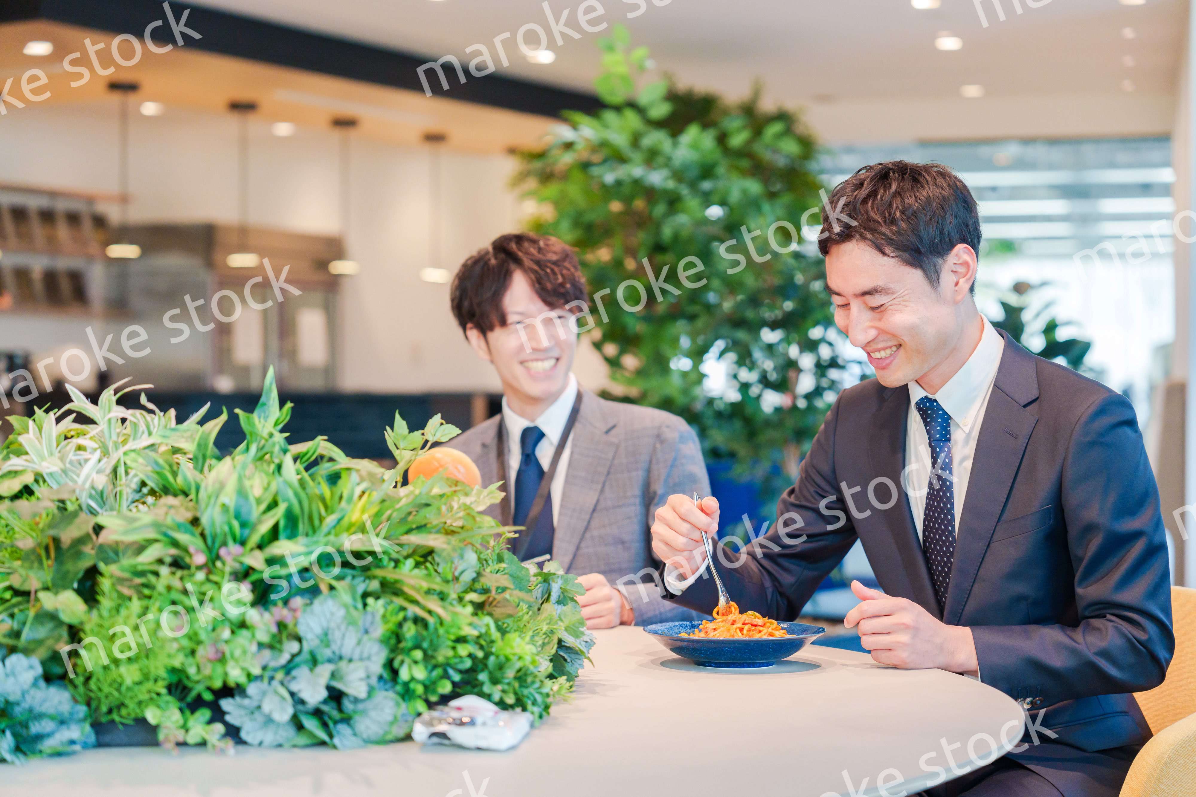 おしゃれなオフィスのカフェテリアでランチをするビジネスマン