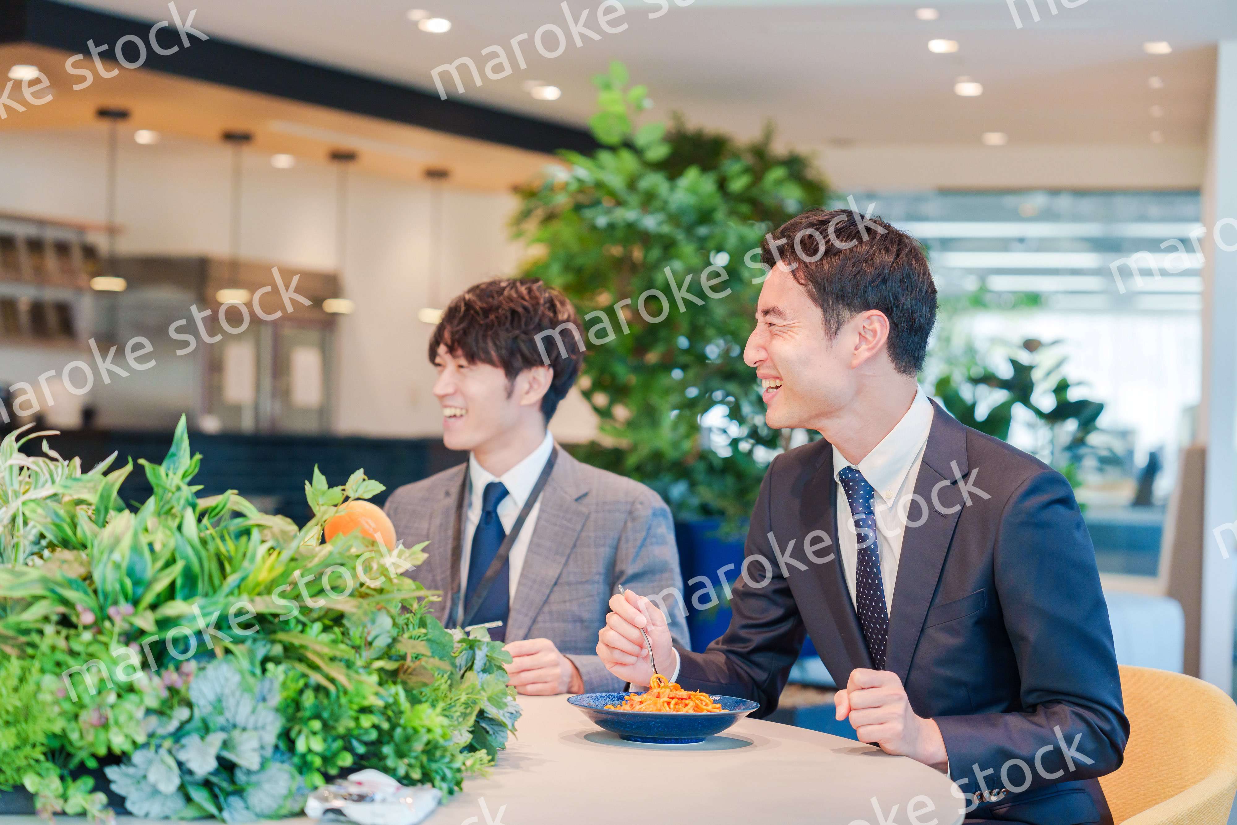 おしゃれなオフィスのカフェテリアでランチをするビジネスマン