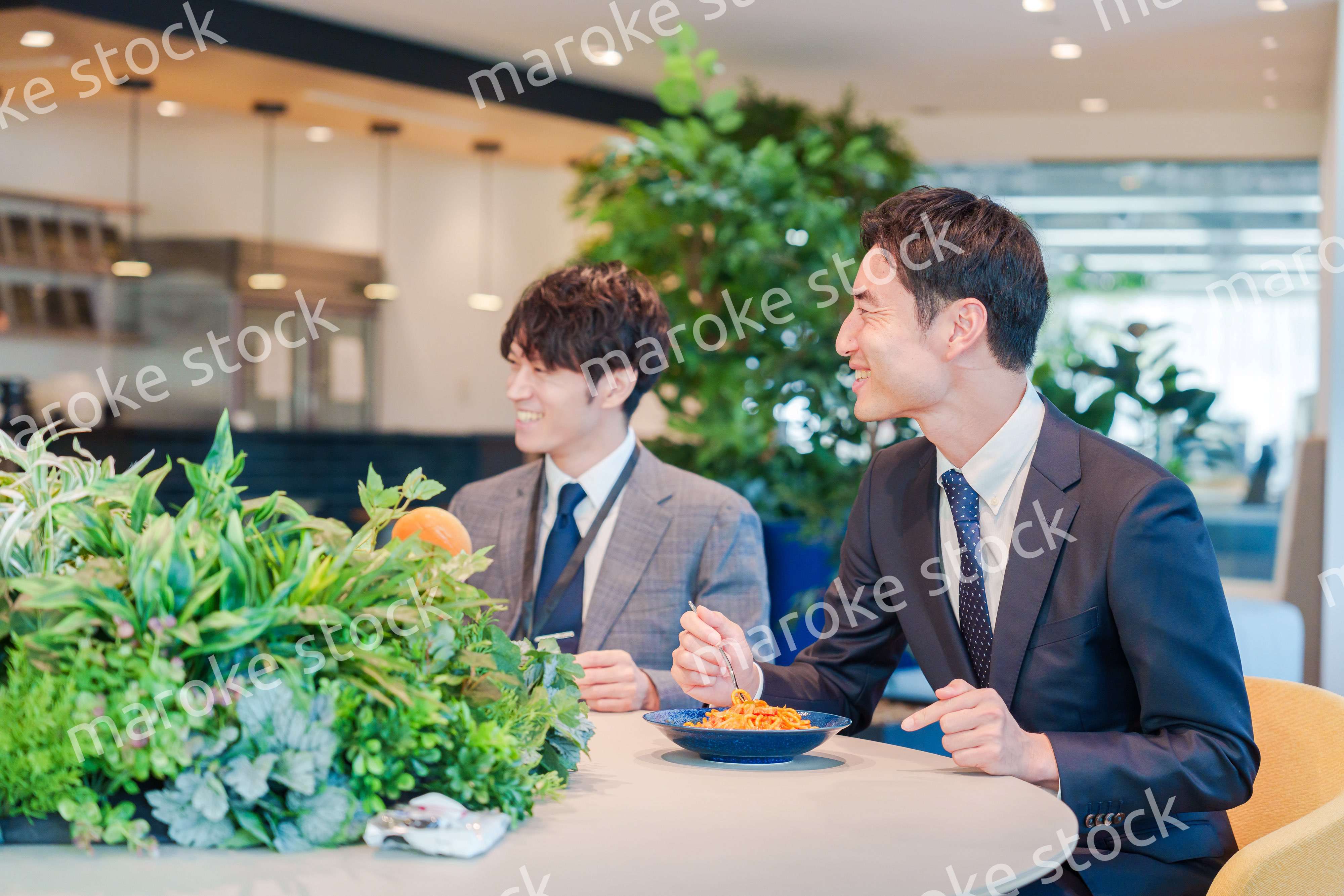 おしゃれなオフィスのカフェテリアでランチをするビジネスマン