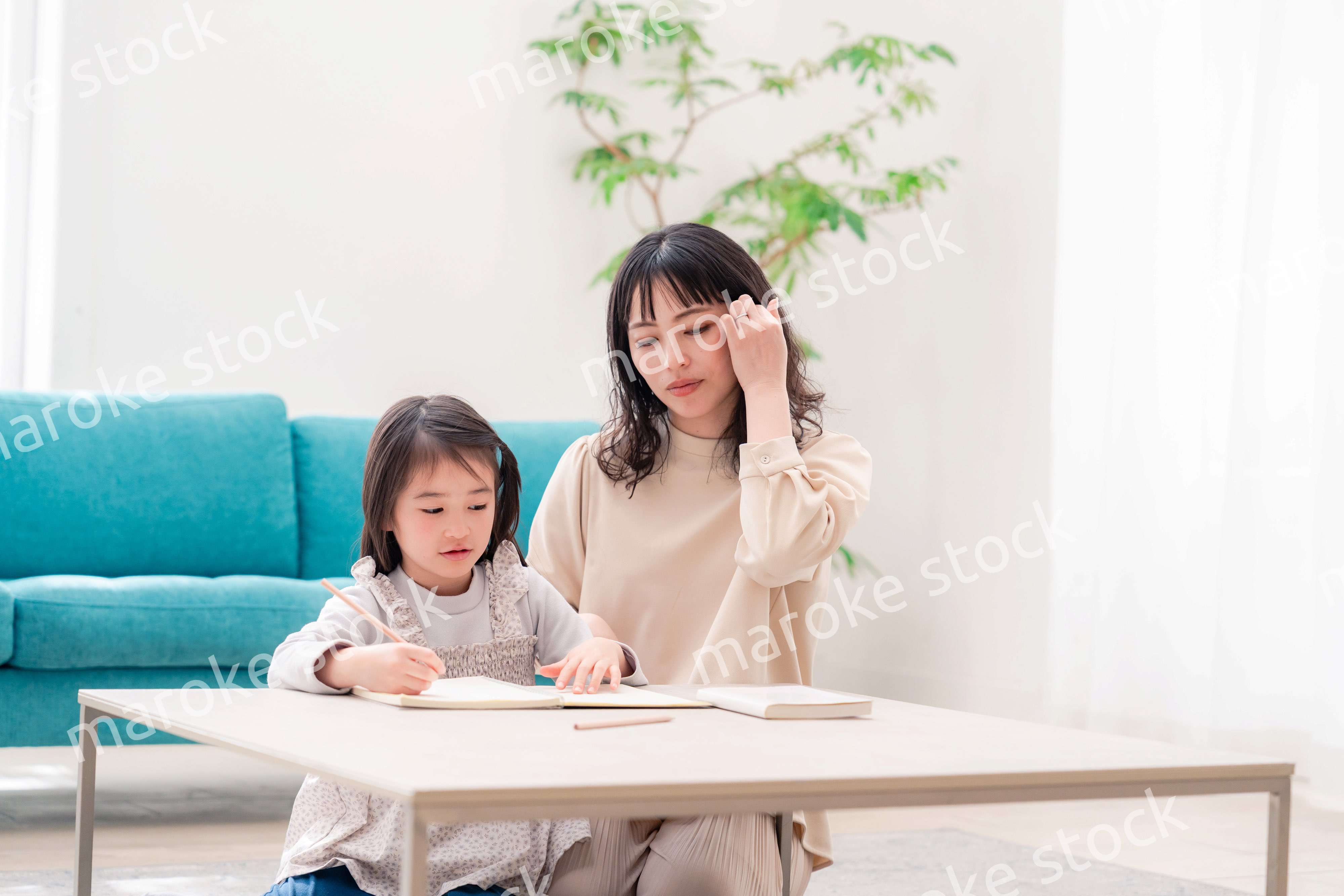 幼稚園児の女の子と一緒に勉強をするお母さん