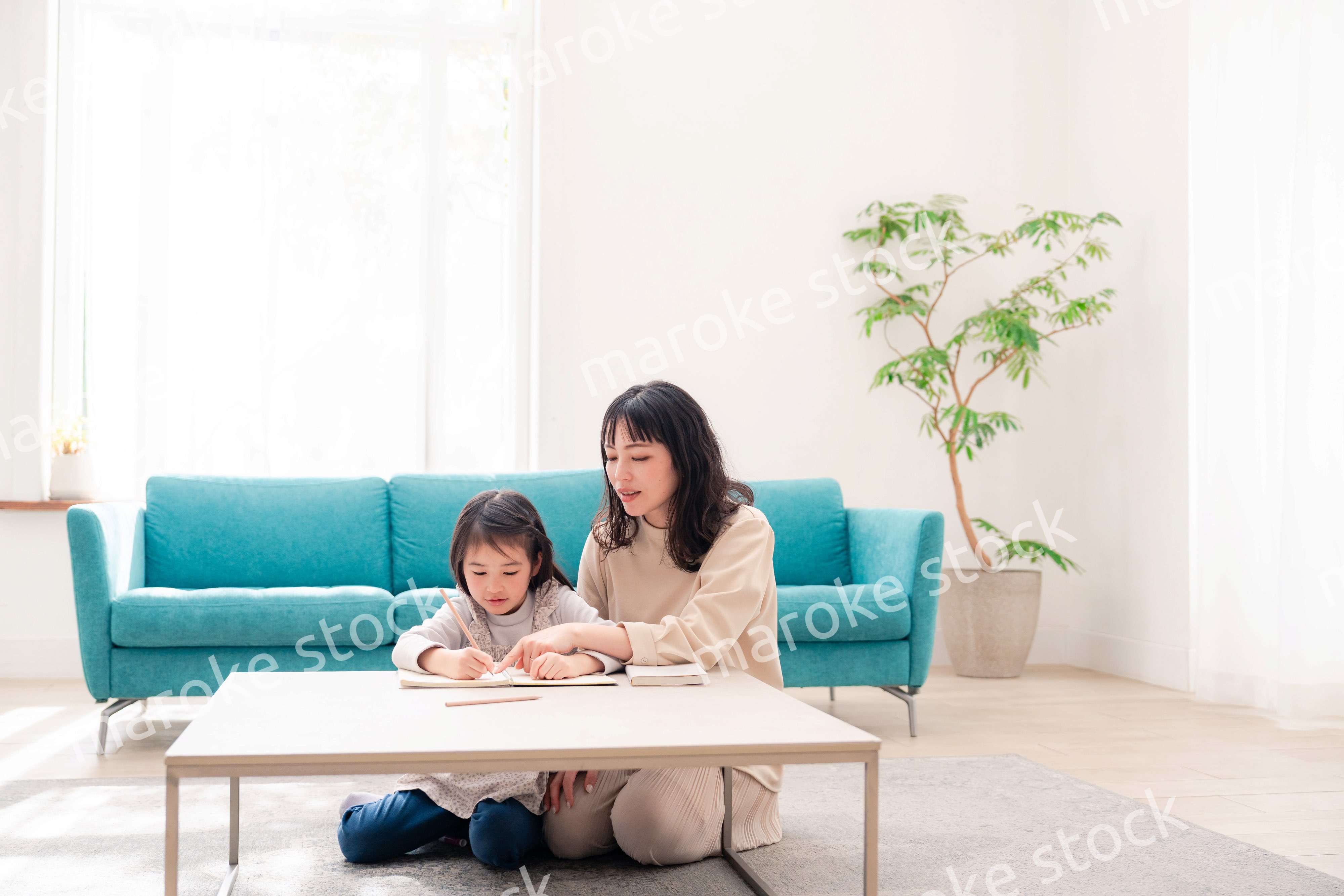 幼稚園児の女の子と一緒に勉強をするお母さん