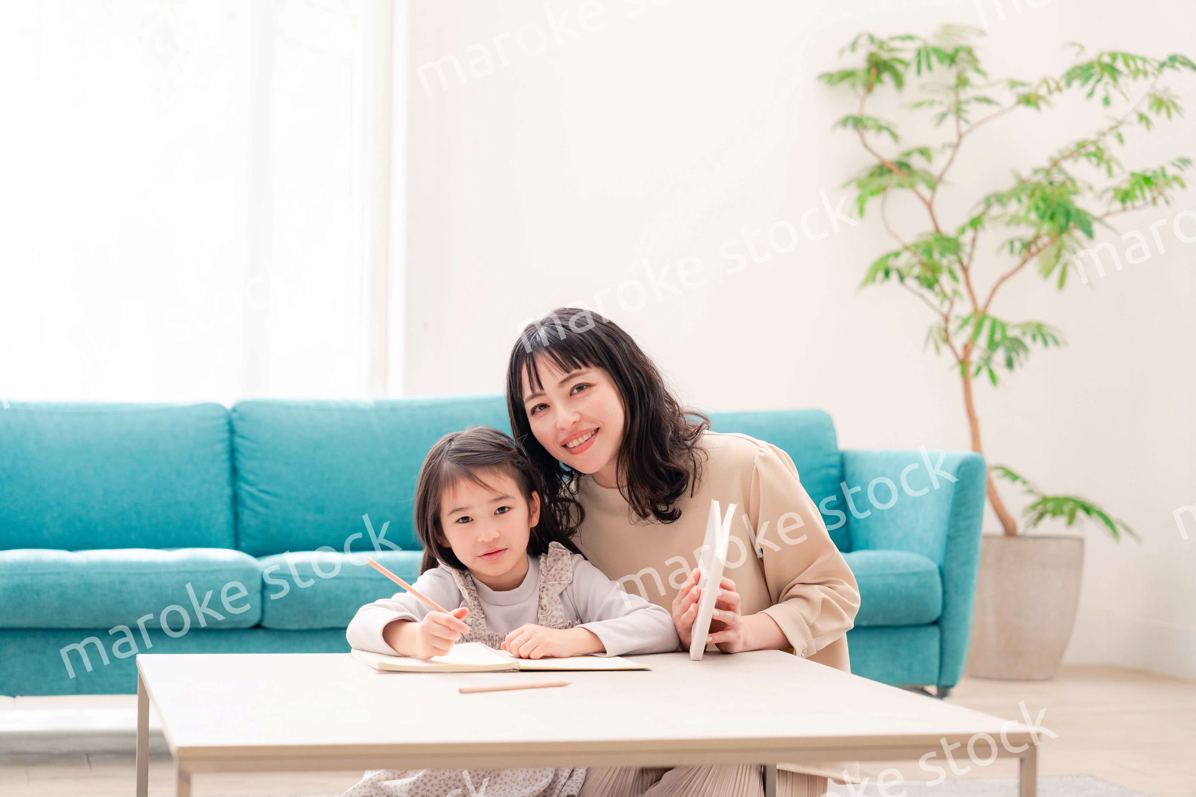 幼稚園児の女の子と一緒に勉強をするお母さん