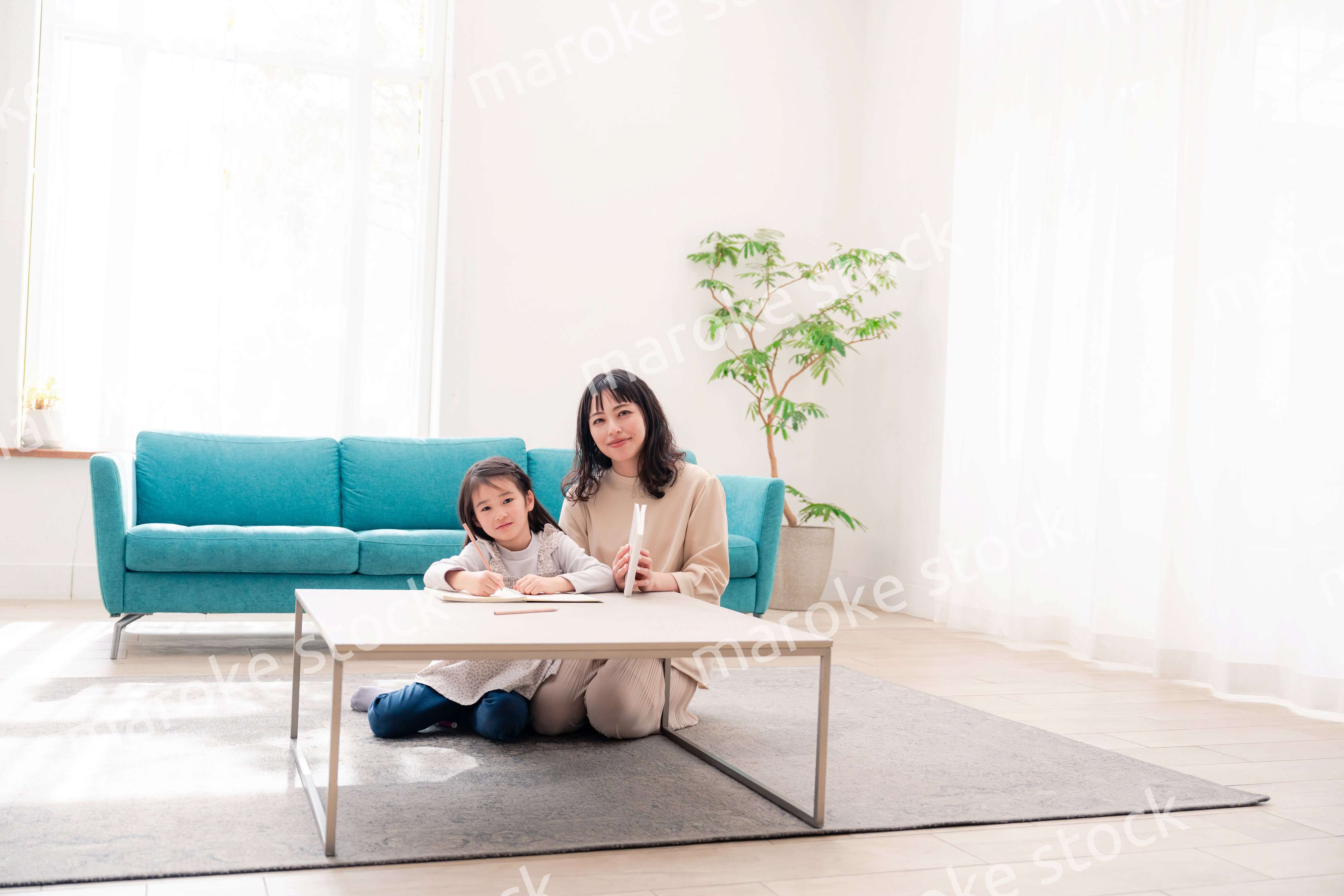 幼稚園児の女の子と一緒に勉強をするお母さん