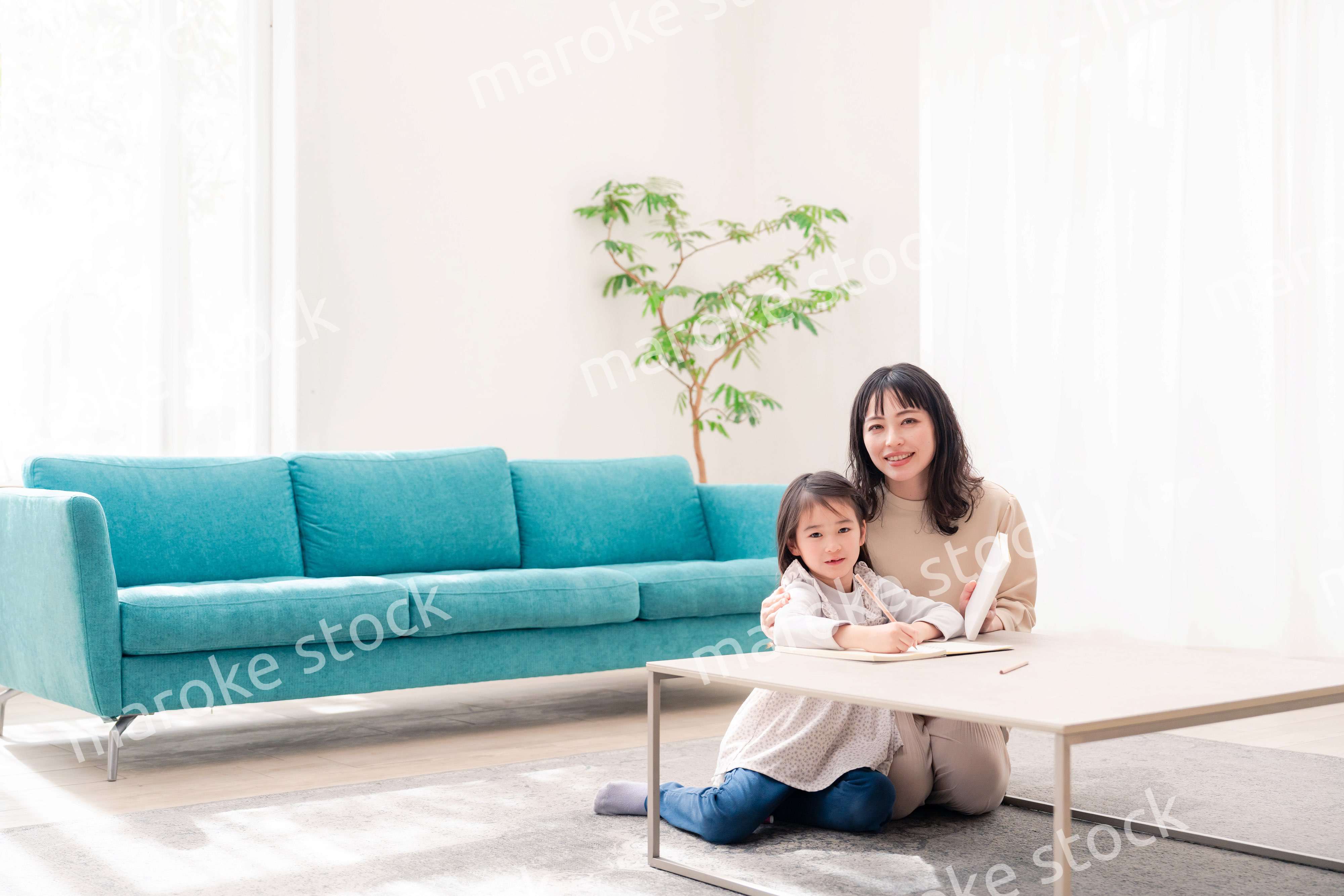 幼稚園児の女の子と一緒に勉強をするお母さん