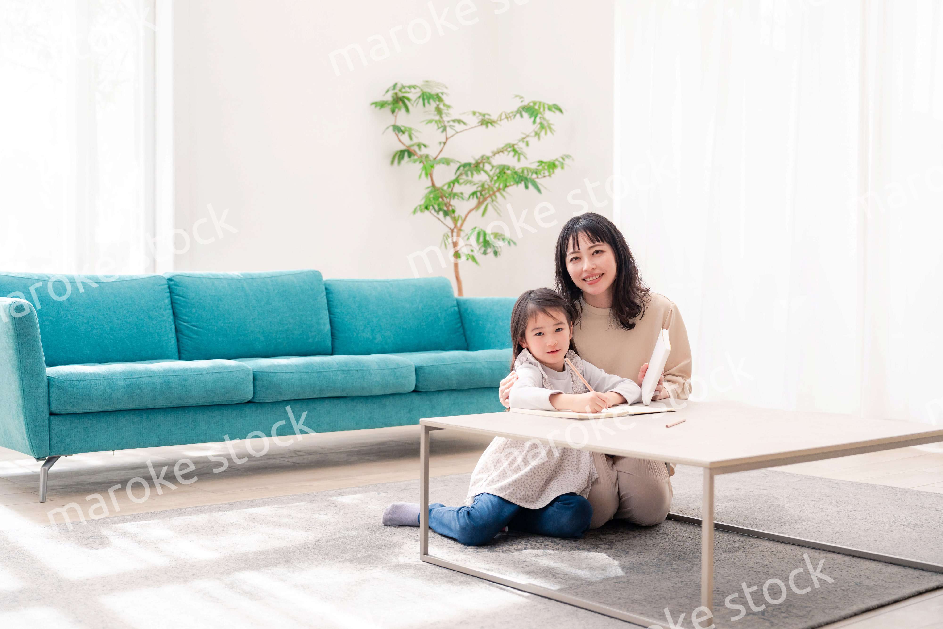 幼稚園児の女の子と一緒に勉強をするお母さん