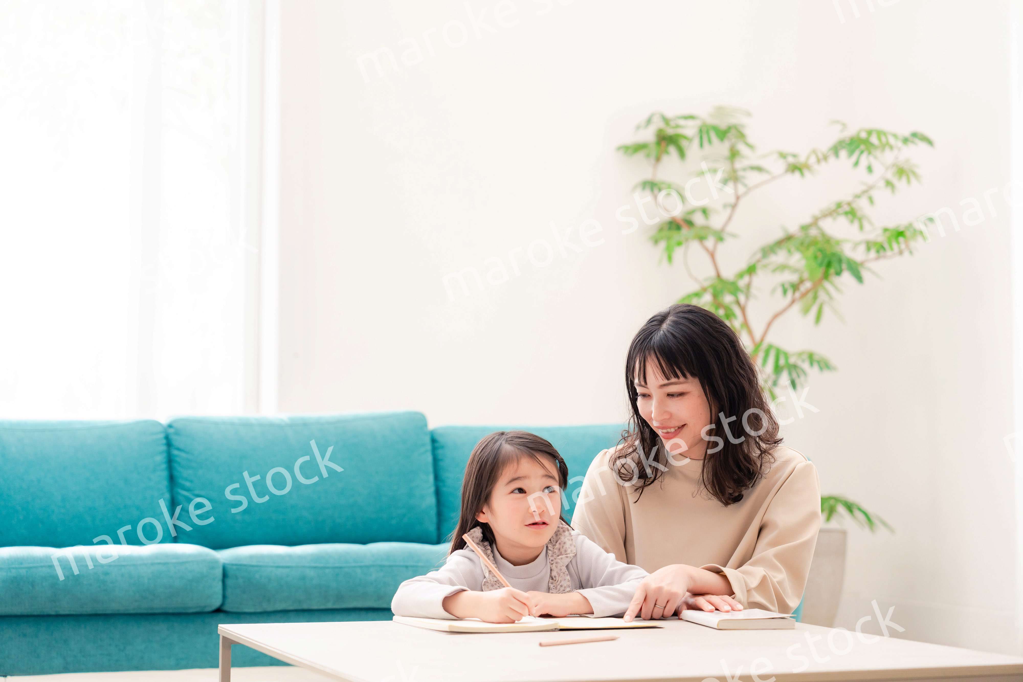 幼稚園児の女の子と一緒に勉強をするお母さん