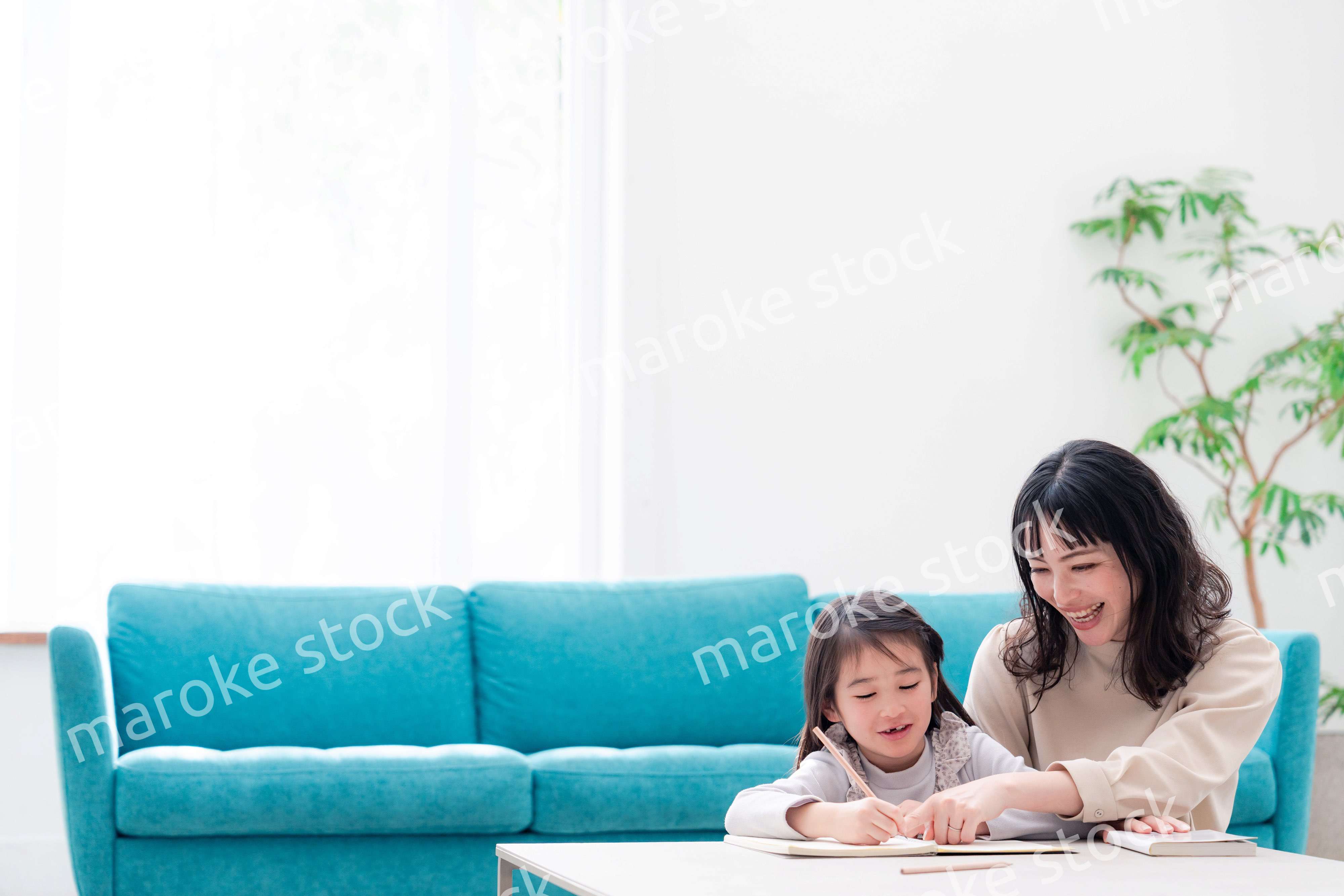 幼稚園児の女の子と一緒に勉強をするお母さん