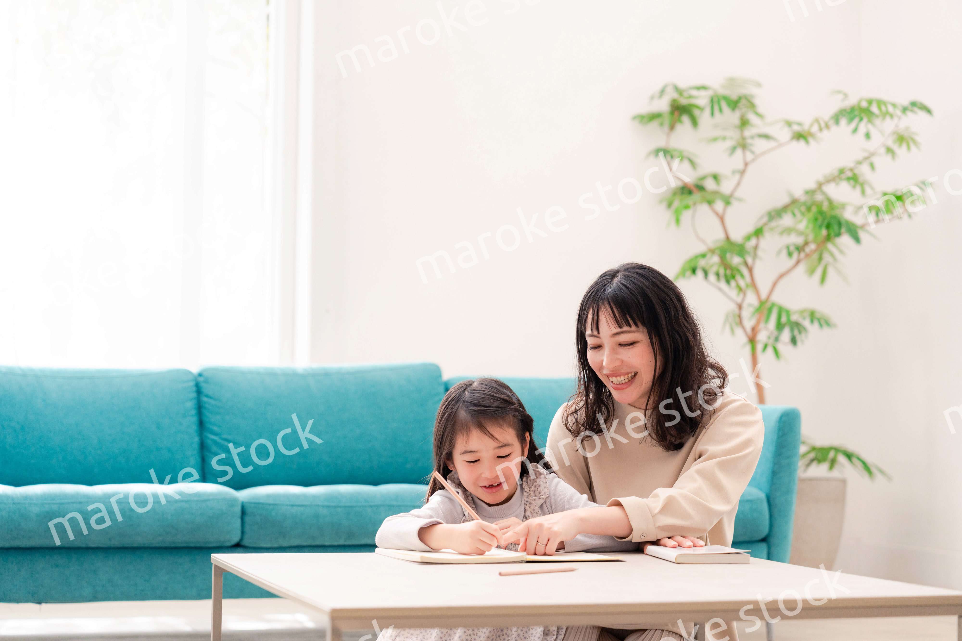 幼稚園児の女の子と一緒に勉強をするお母さん