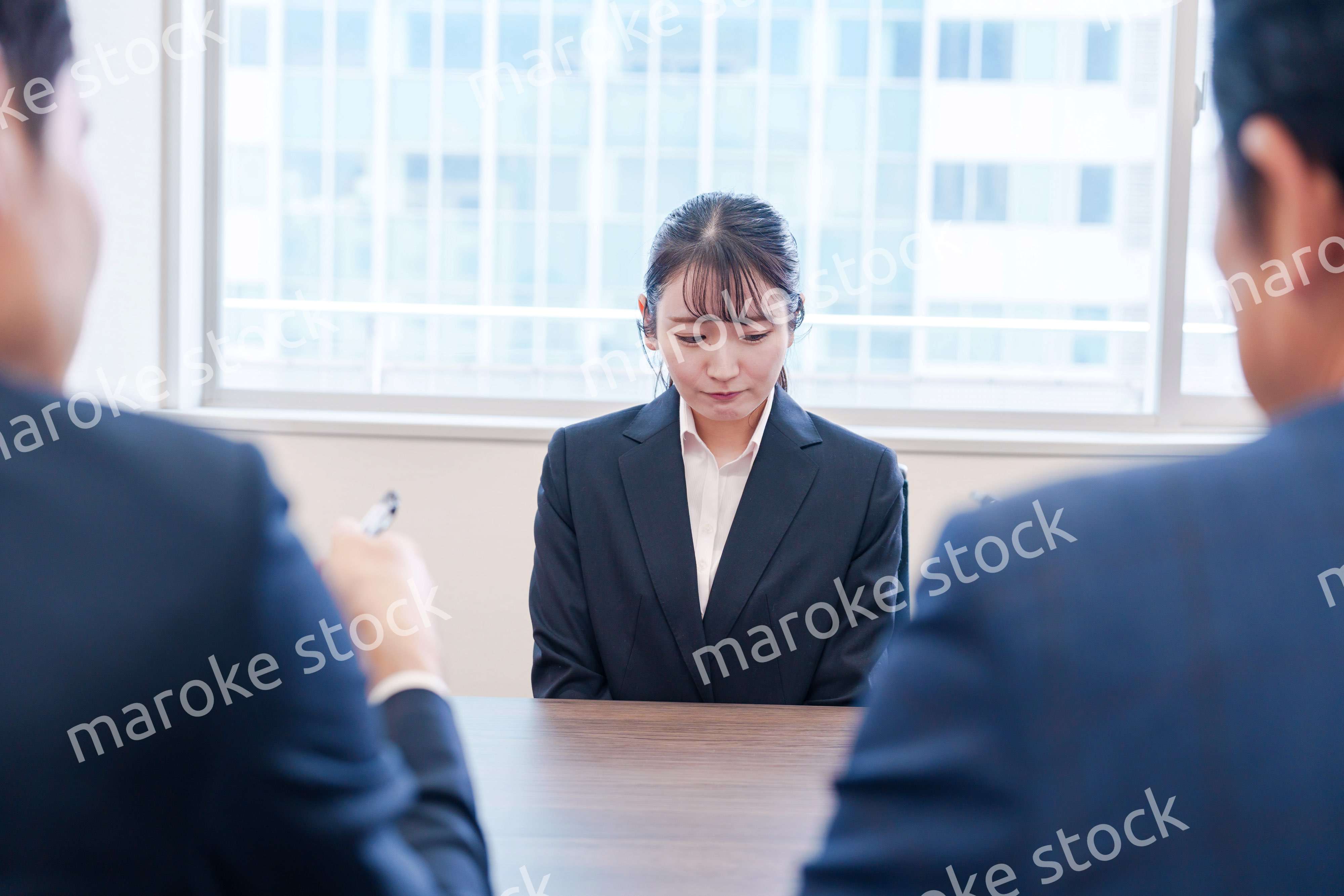 オフィスで上司に詰められて悲しい表情をする女性社員