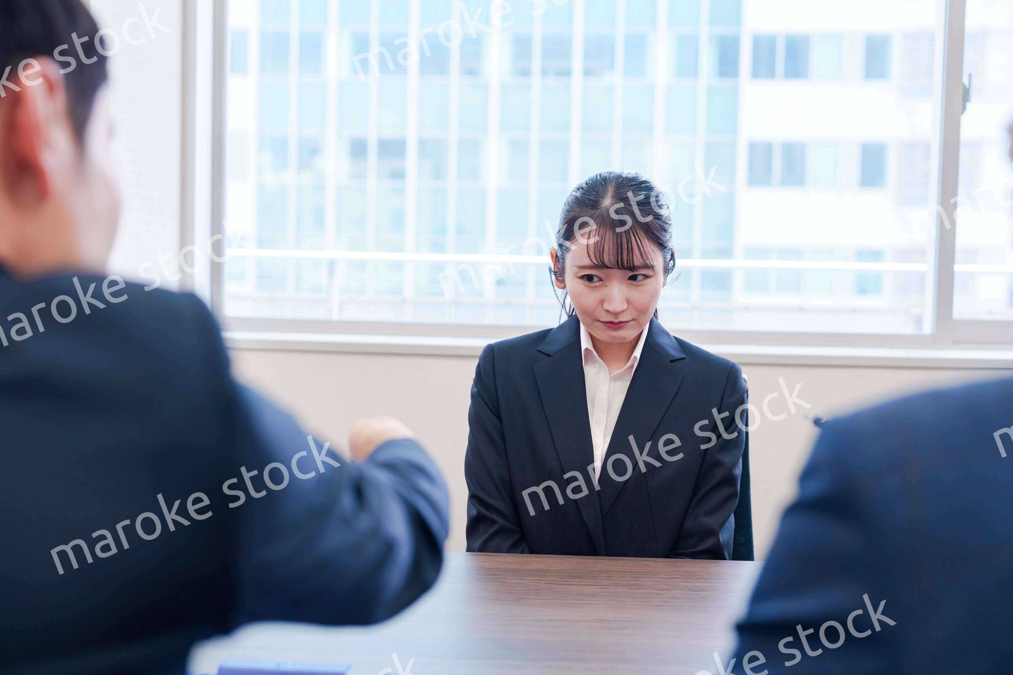 オフィスで上司に詰められて悲しい表情をする女性社員