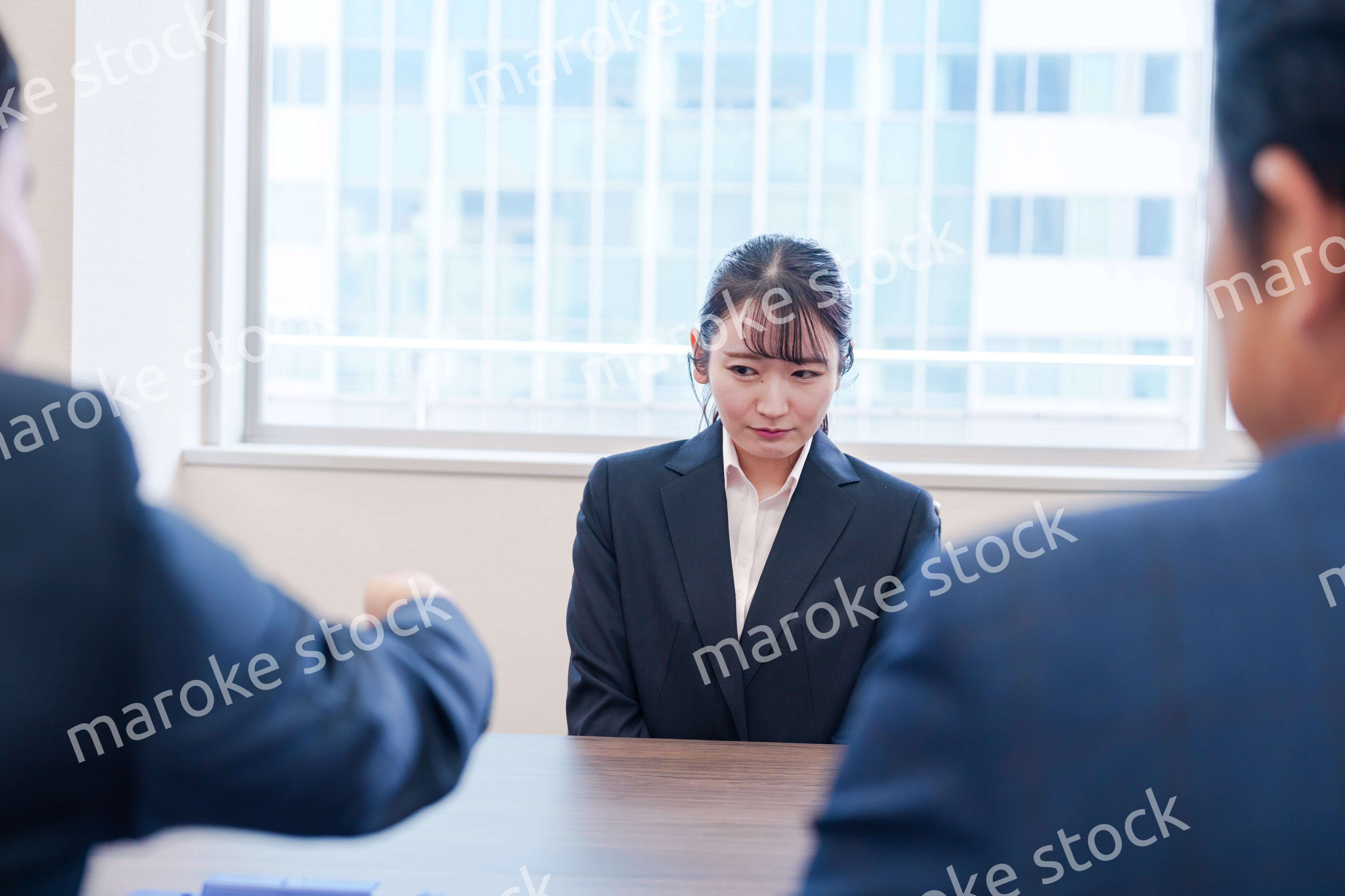 オフィスで上司に詰められて悲しい表情をする女性社員