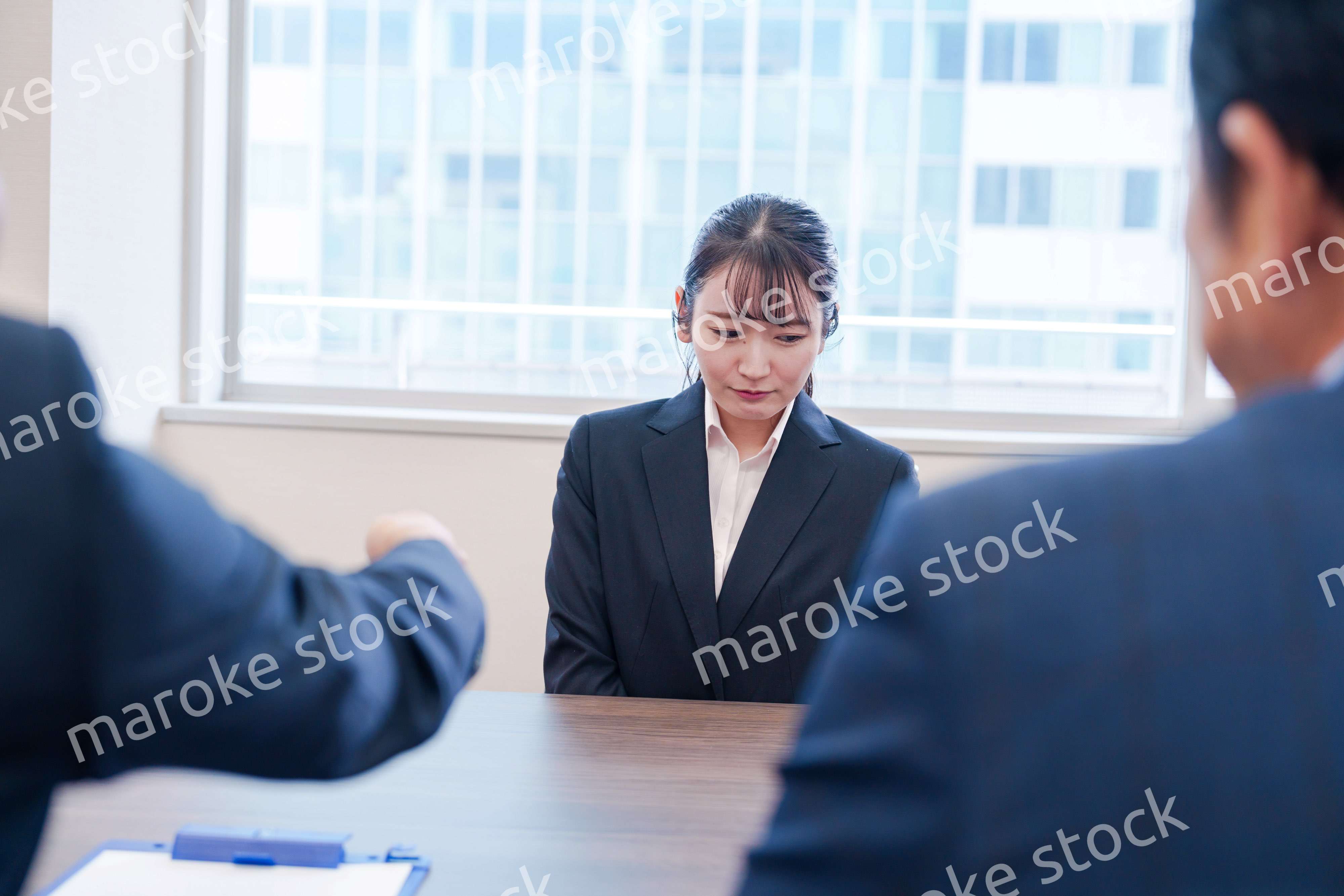 オフィスで上司に詰められて悲しい表情をする女性社員