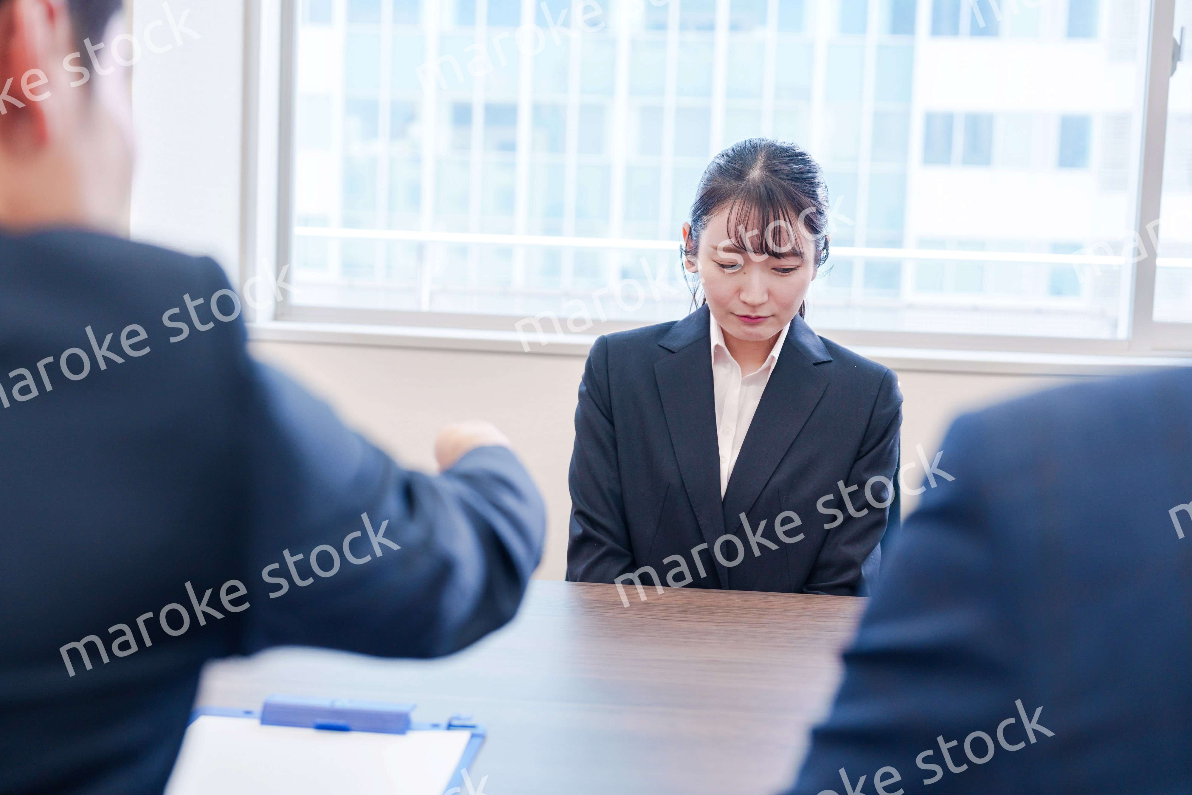 オフィスで上司に詰められて悲しい表情をする女性社員