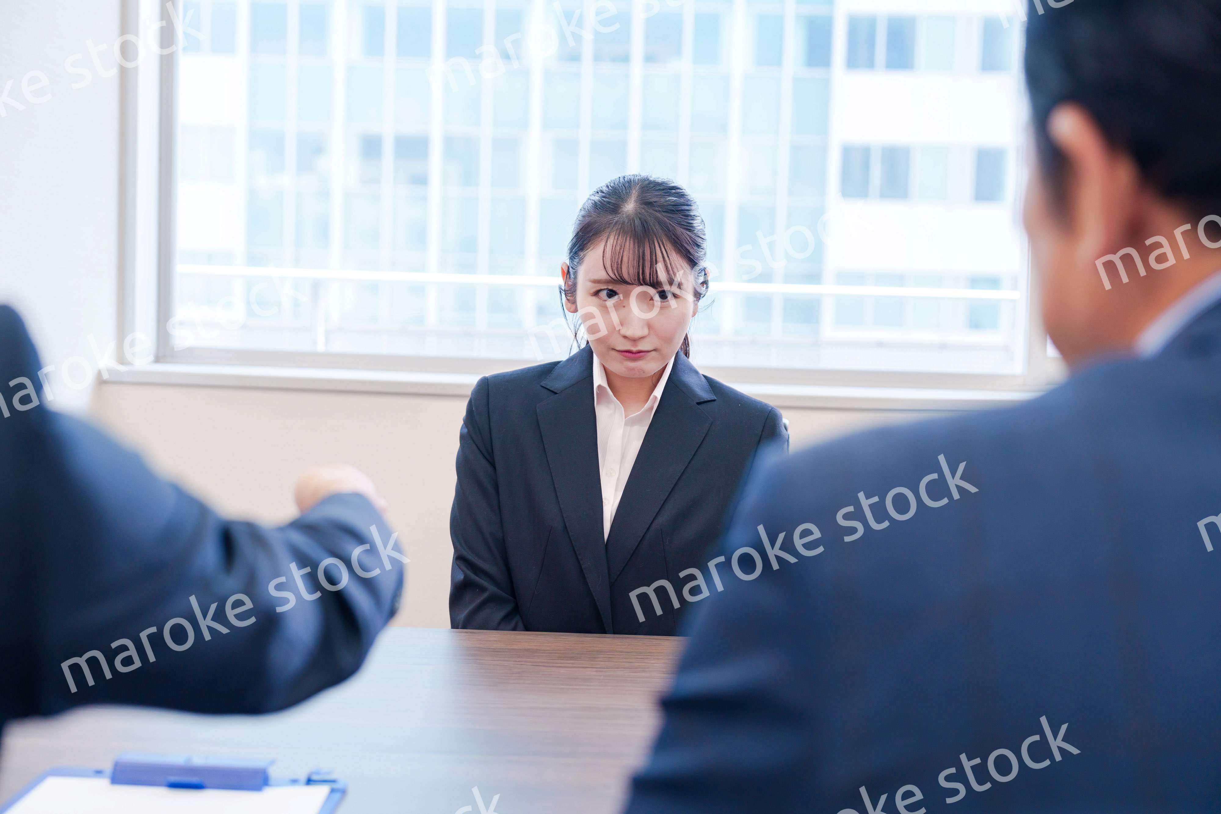 オフィスで上司に詰められて悲しい表情をする女性社員