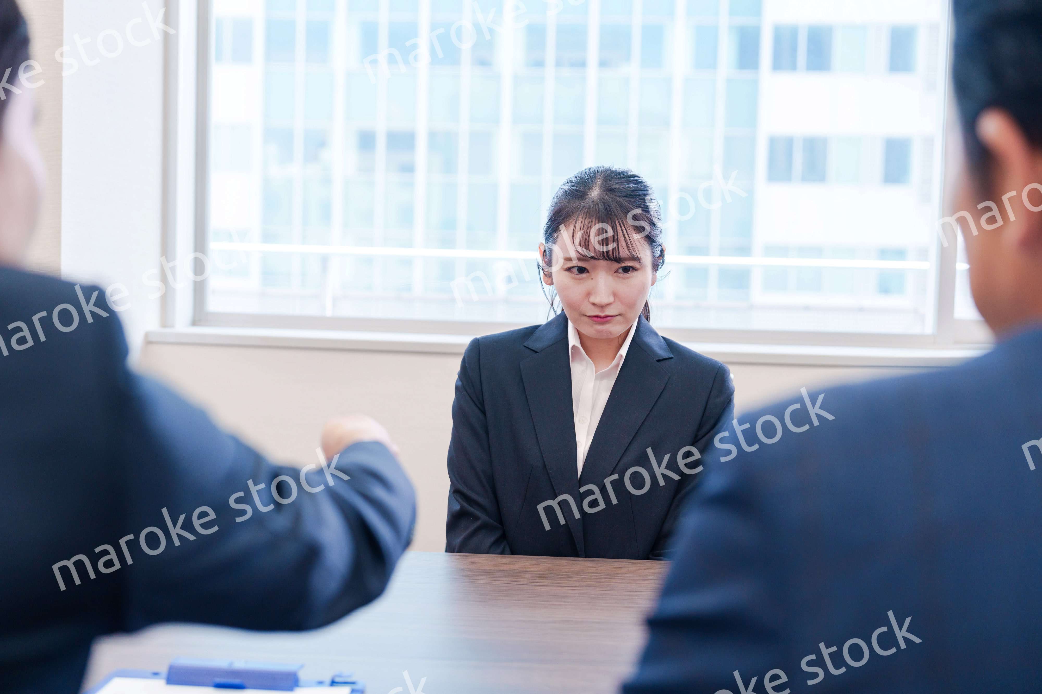 オフィスで上司に詰められて悲しい表情をする女性社員