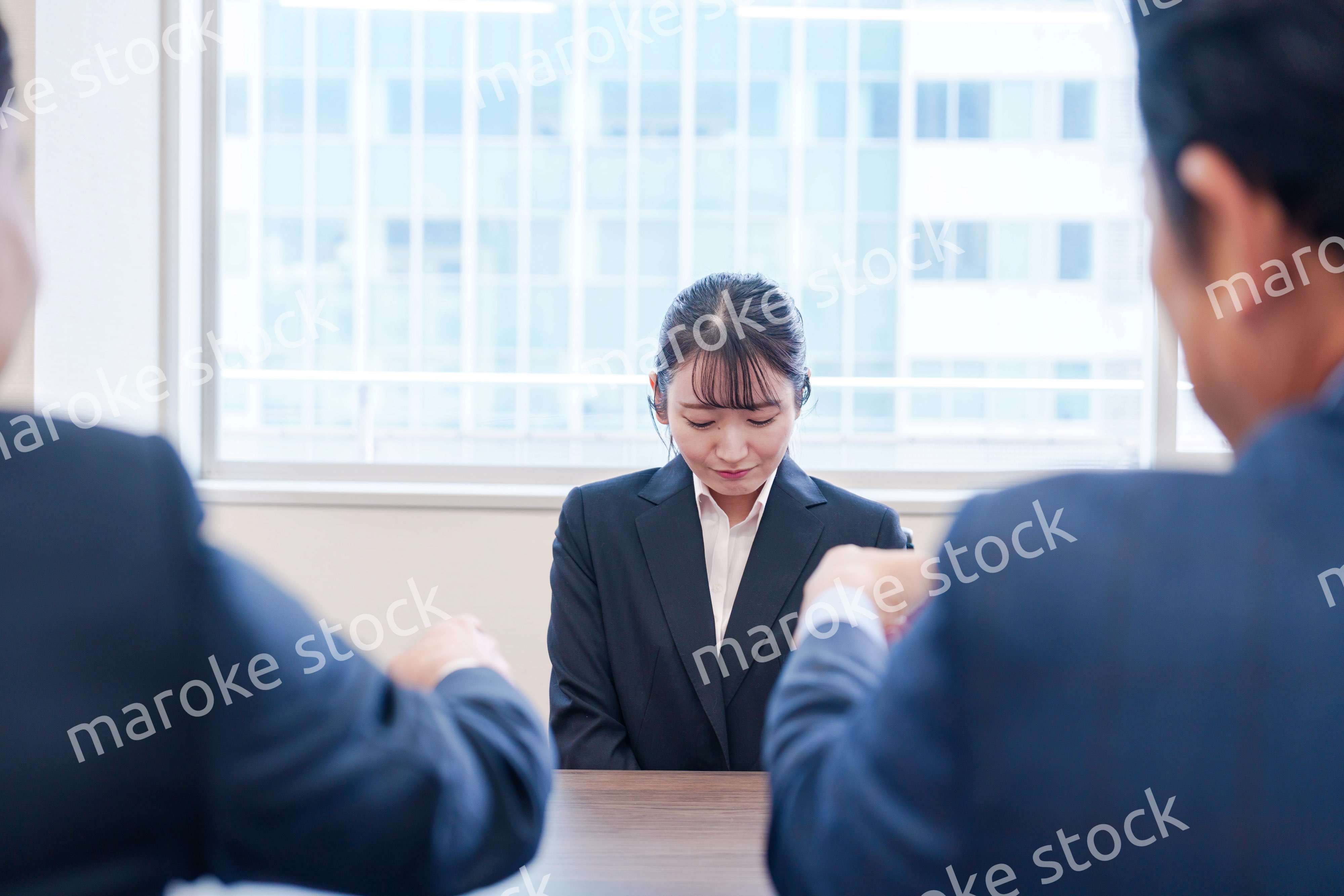 オフィスで上司に詰められて悲しい表情をする女性社員