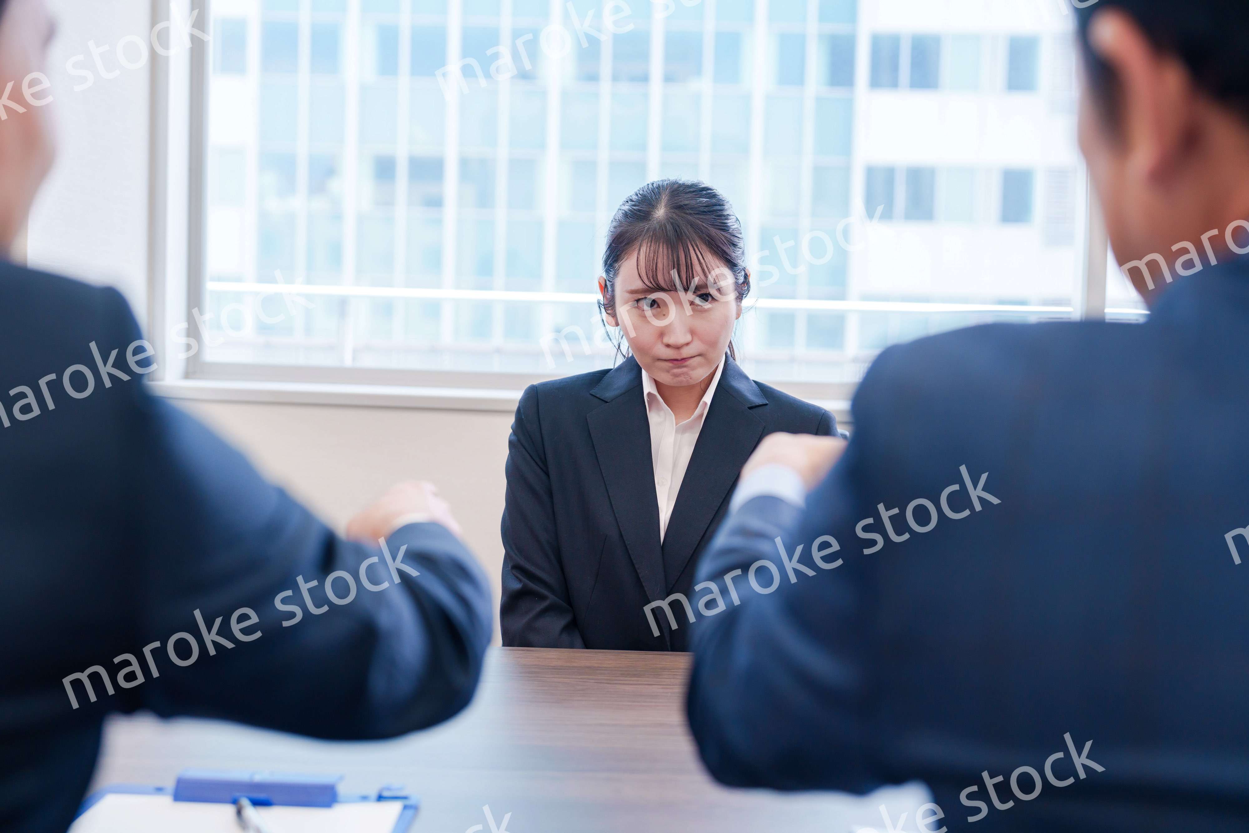 オフィスで上司に詰められて悲しい表情をする女性社員