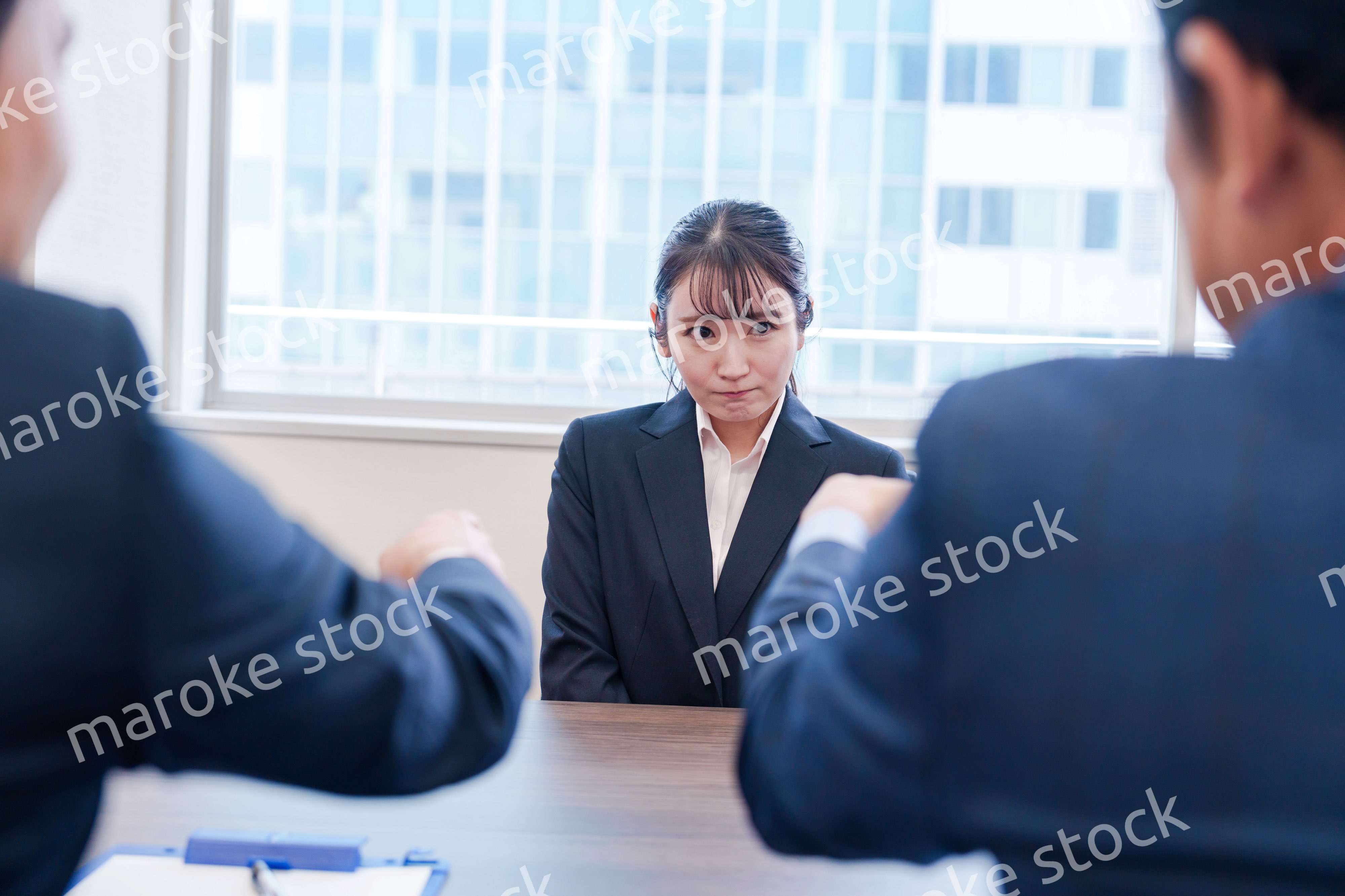 オフィスで上司に詰められて悲しい表情をする女性社員