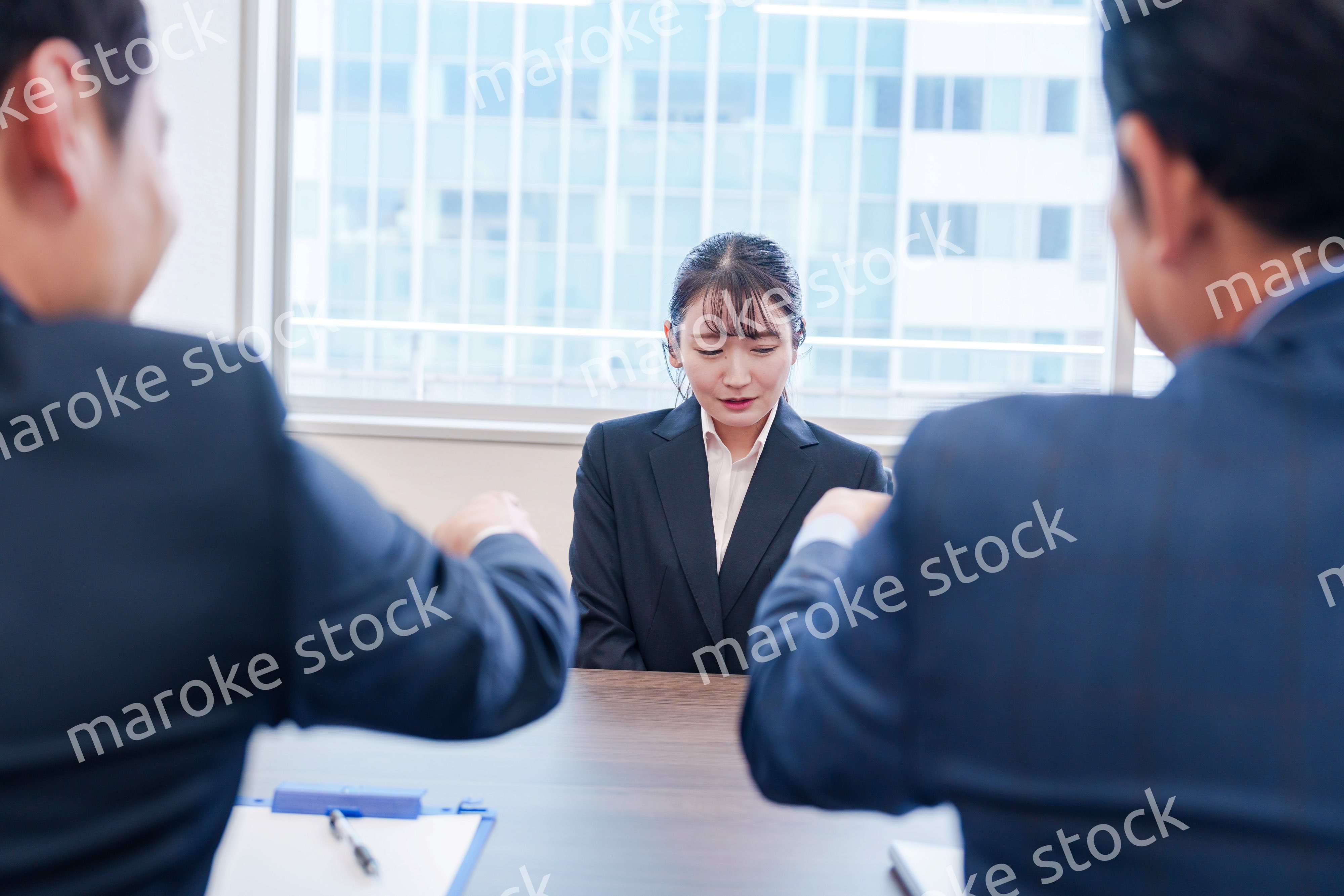 オフィスで上司に詰められて悲しい表情をする女性社員