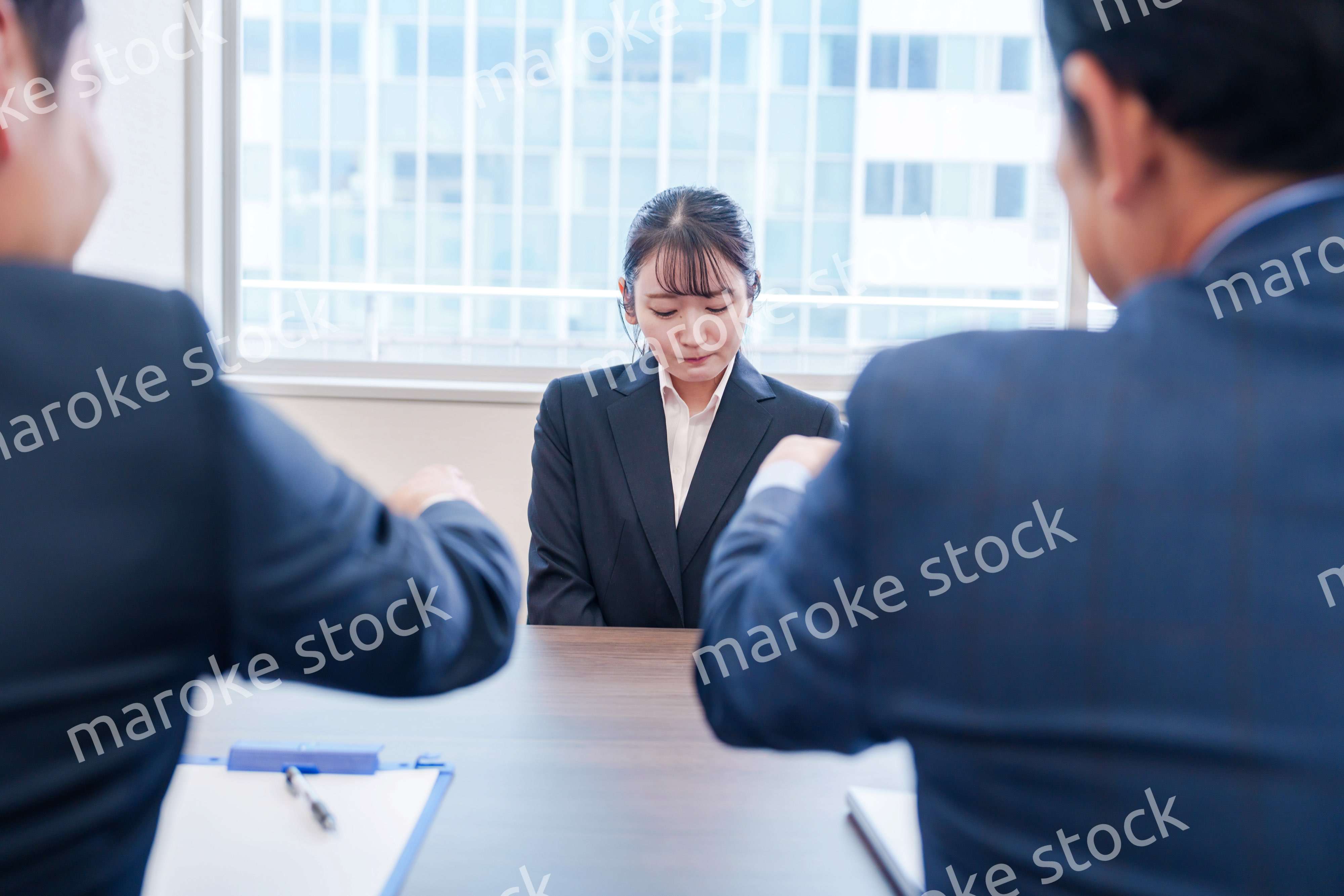 オフィスで上司に詰められて悲しい表情をする女性社員