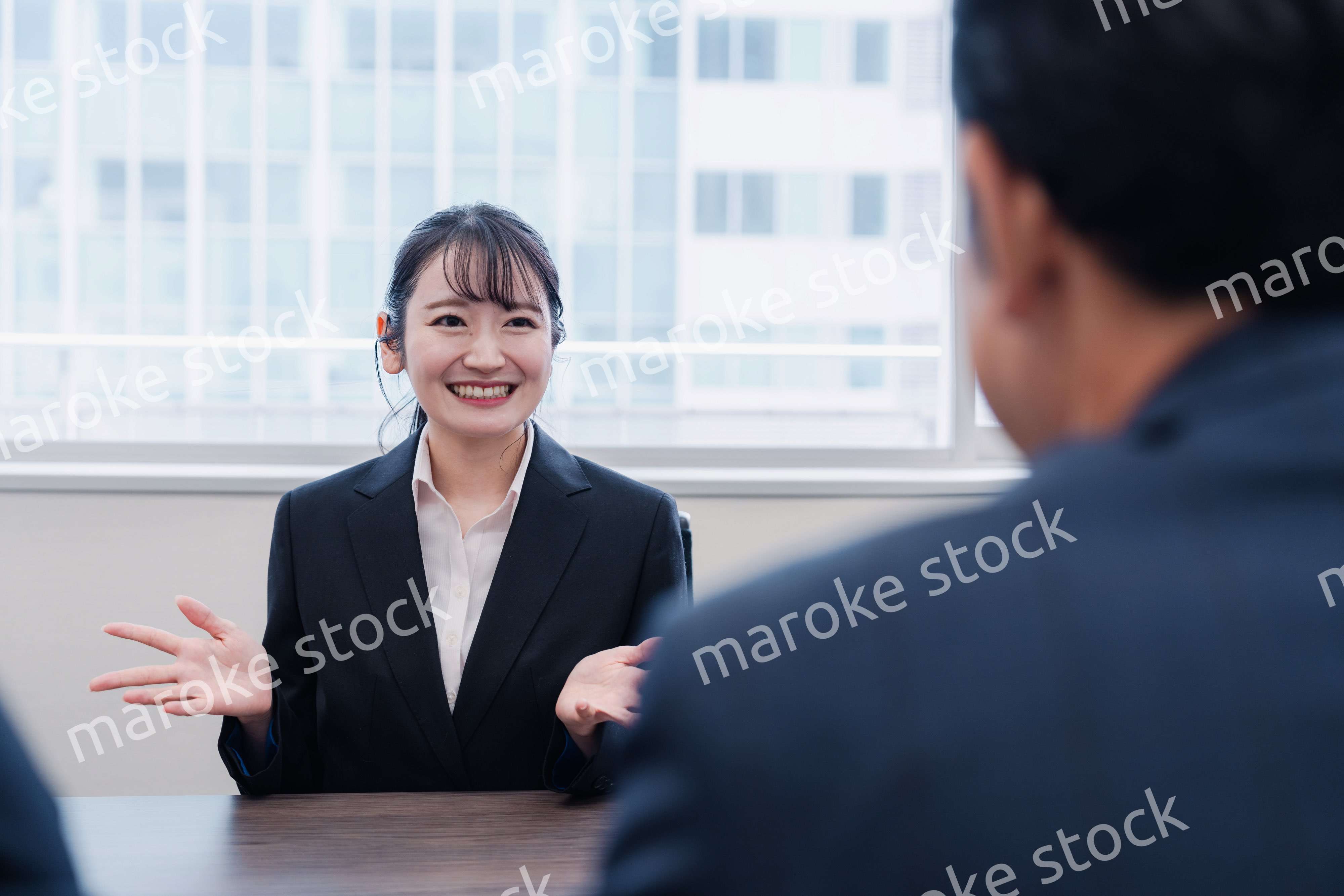 面接で笑顔で話す女性の就活生