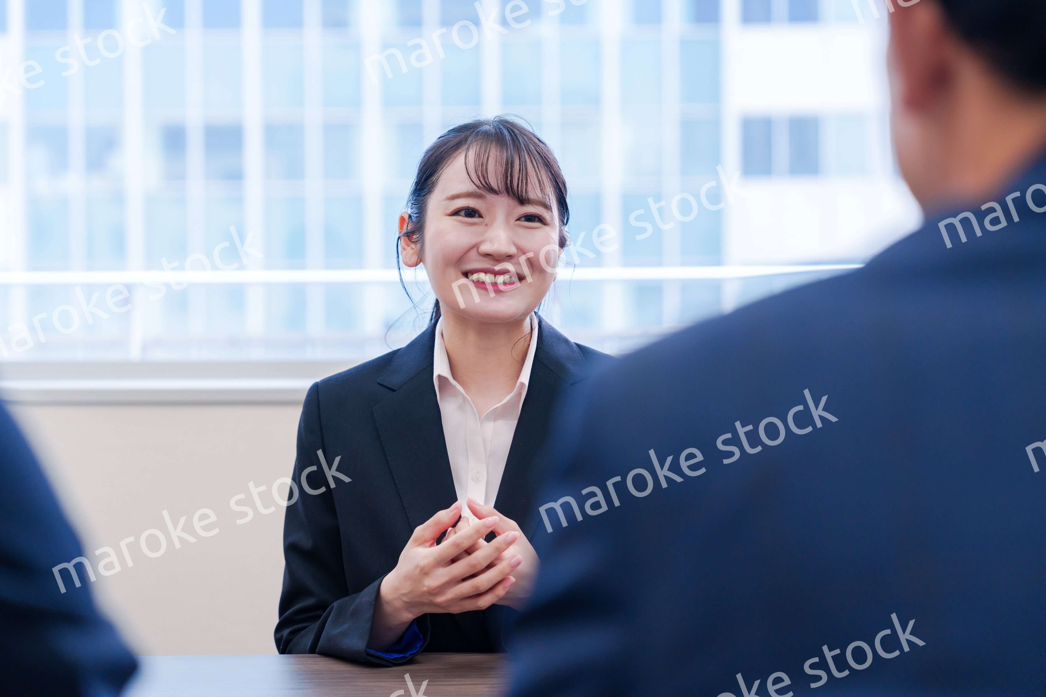 面接で笑顔で話す女性の就活生