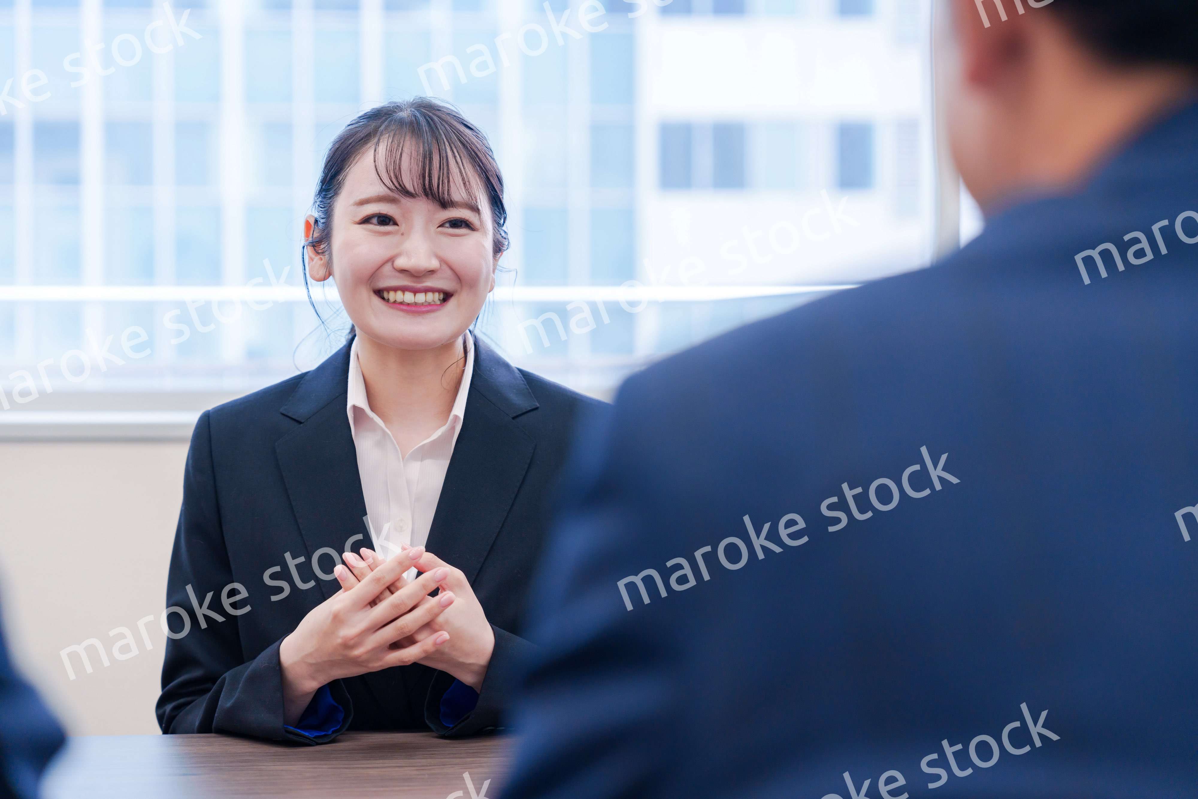 面接で笑顔で話す女性の就活生