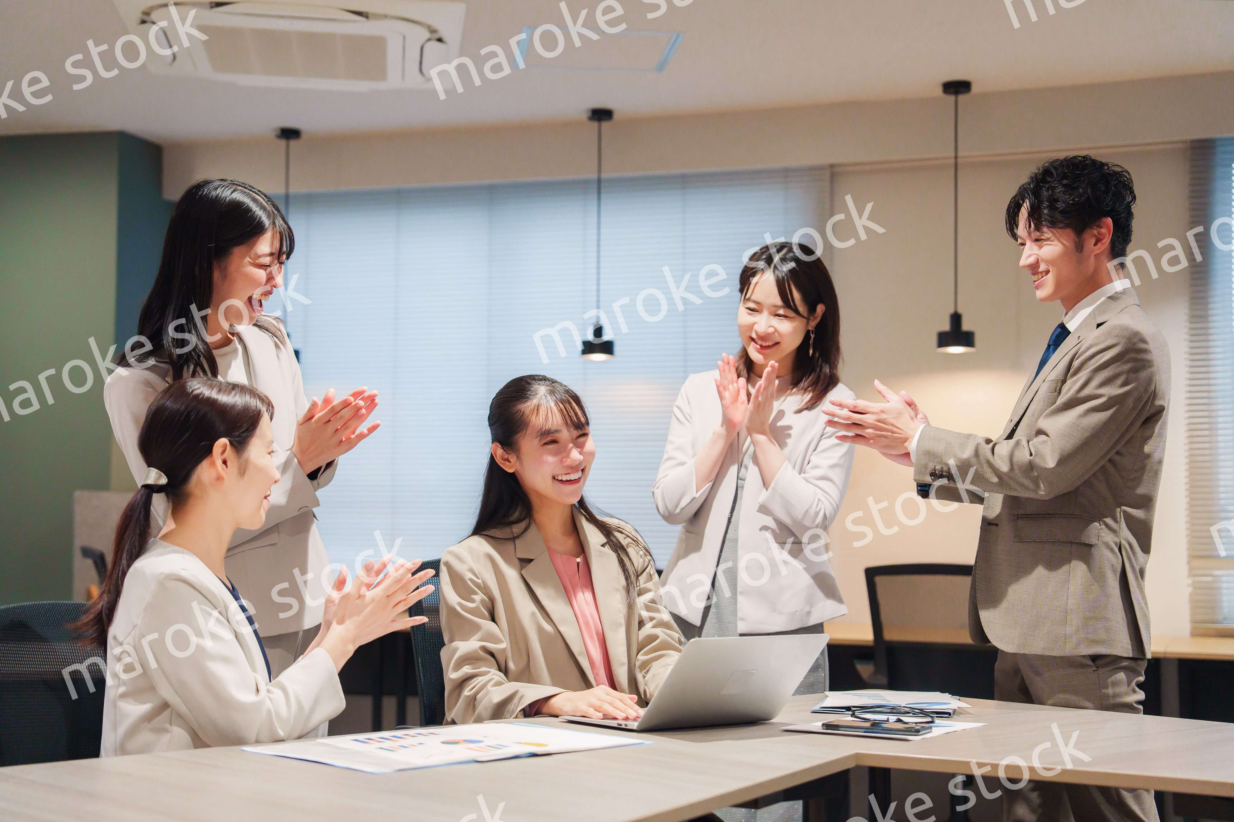 オフィスメンバーから拍手喝采される女性社員