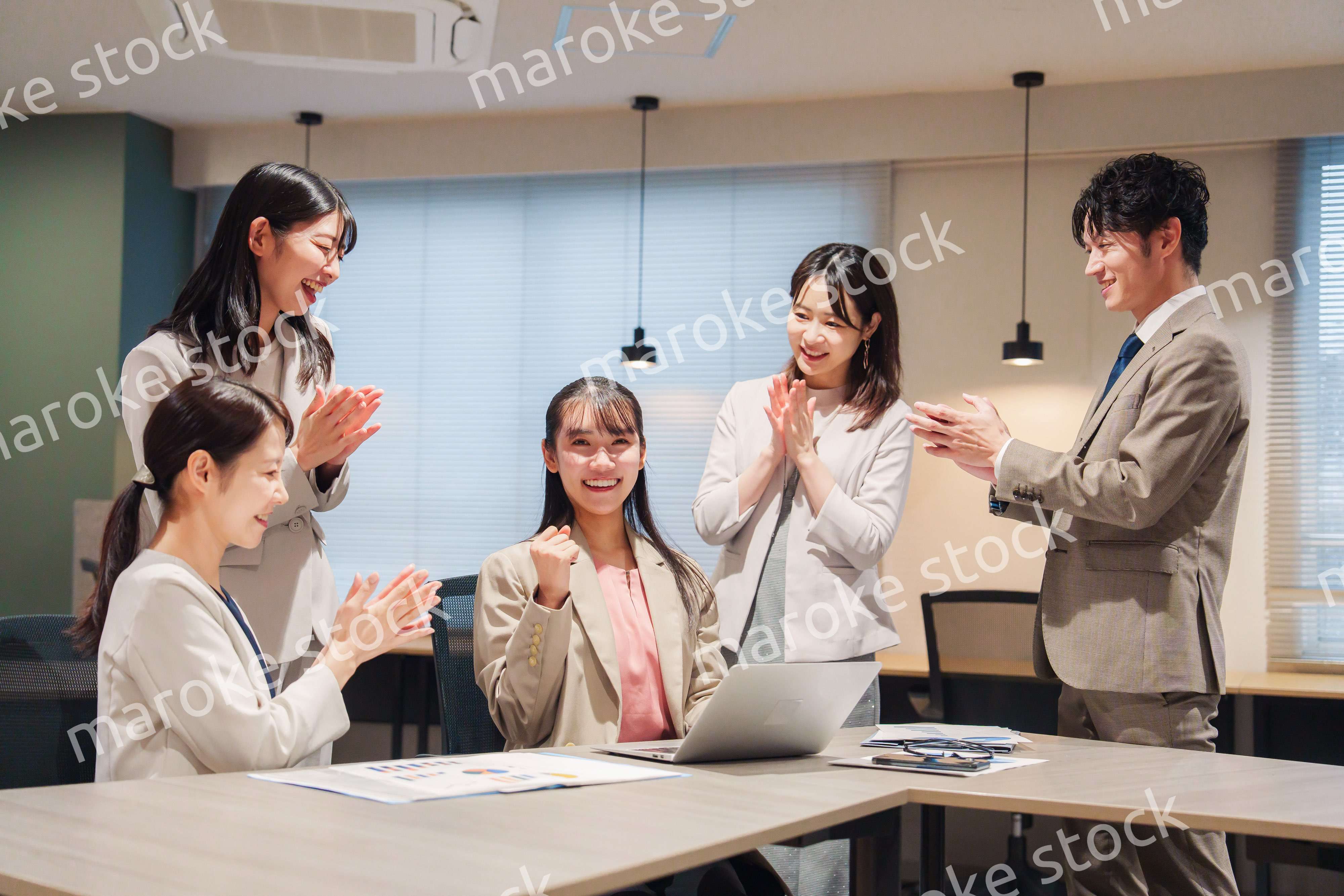 オフィスメンバーから拍手喝采される女性社員