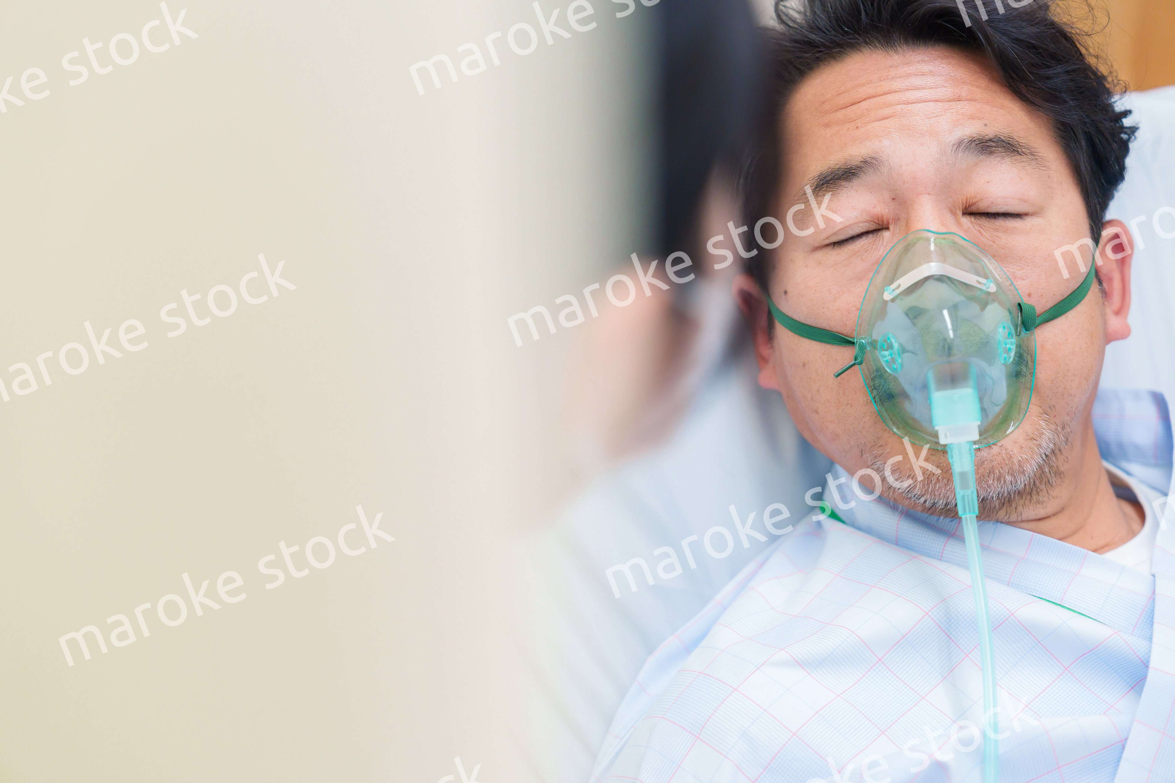 人工呼吸器をつけて話をする入院患者の男性