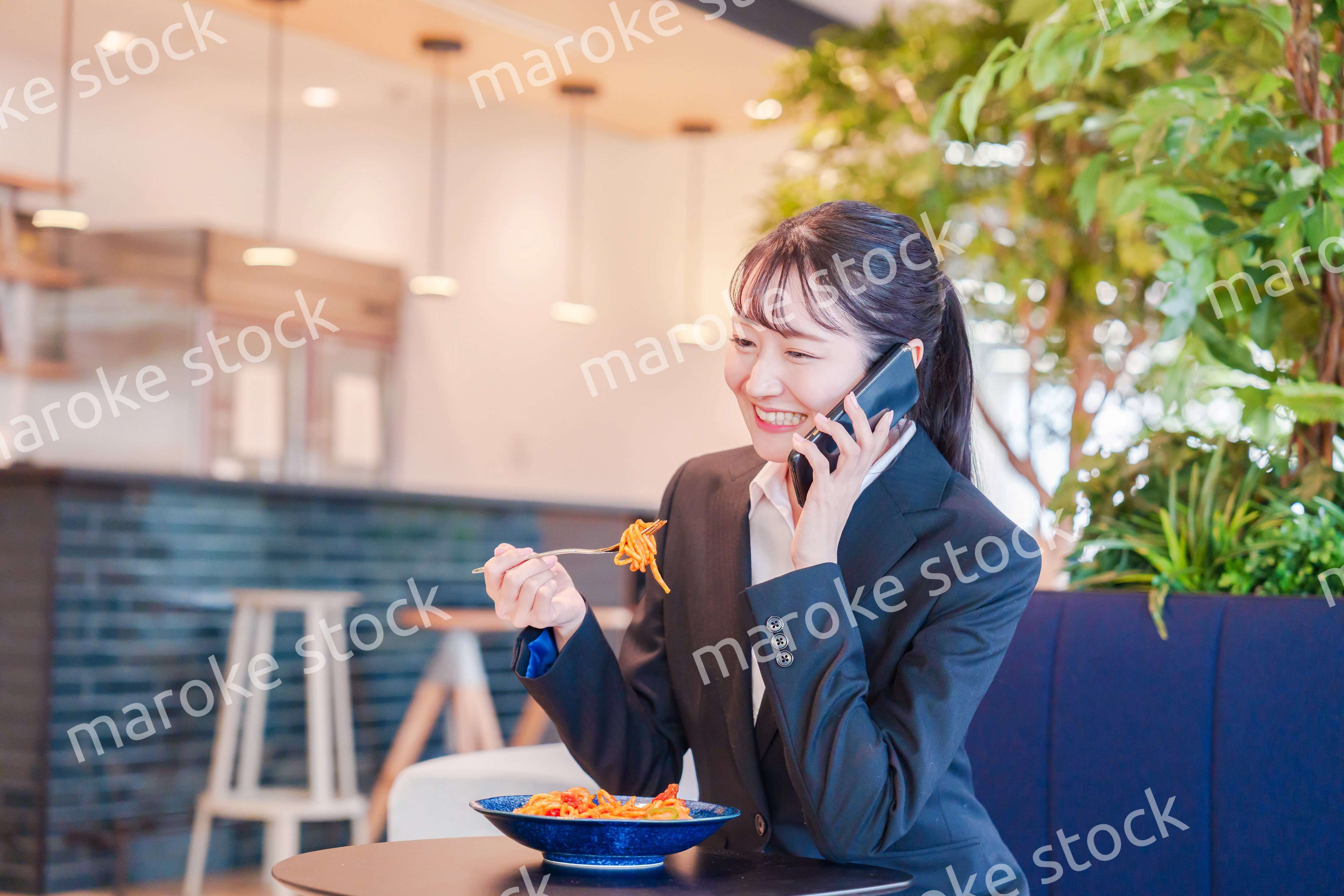 スマホで笑顔で電話をする就活生の女性