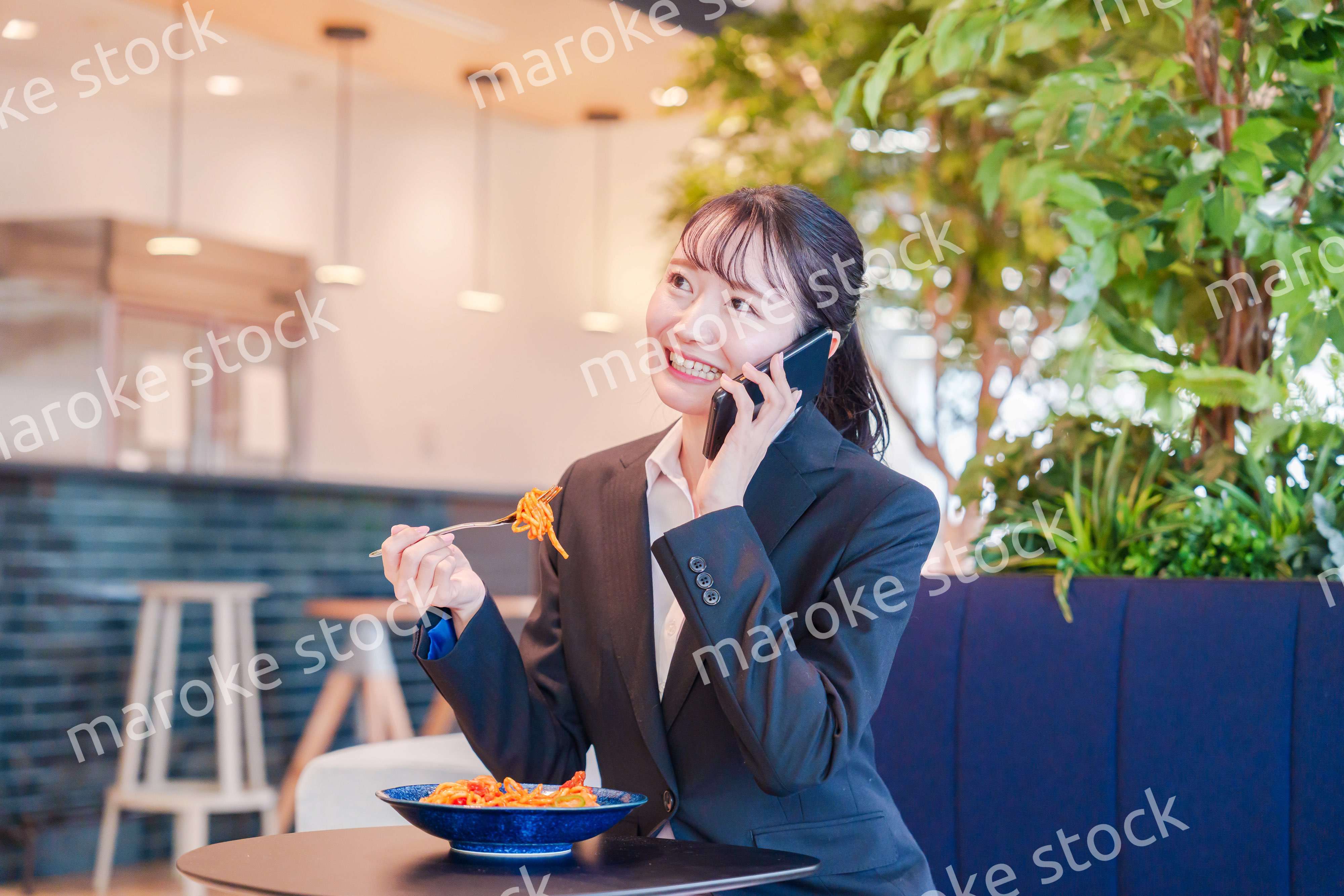 スマホで笑顔で電話をする就活生の女性