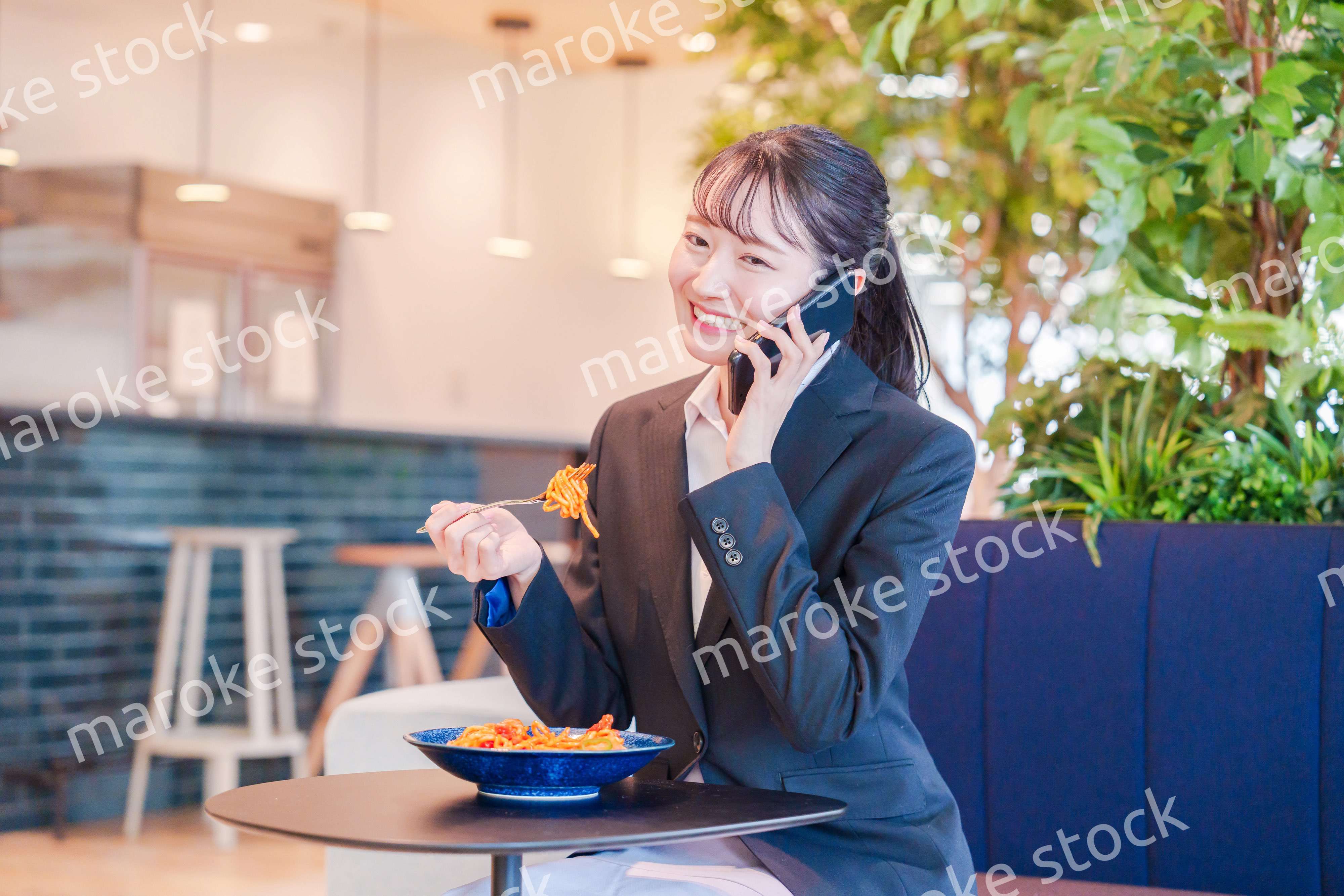 スマホで笑顔で電話をする就活生の女性