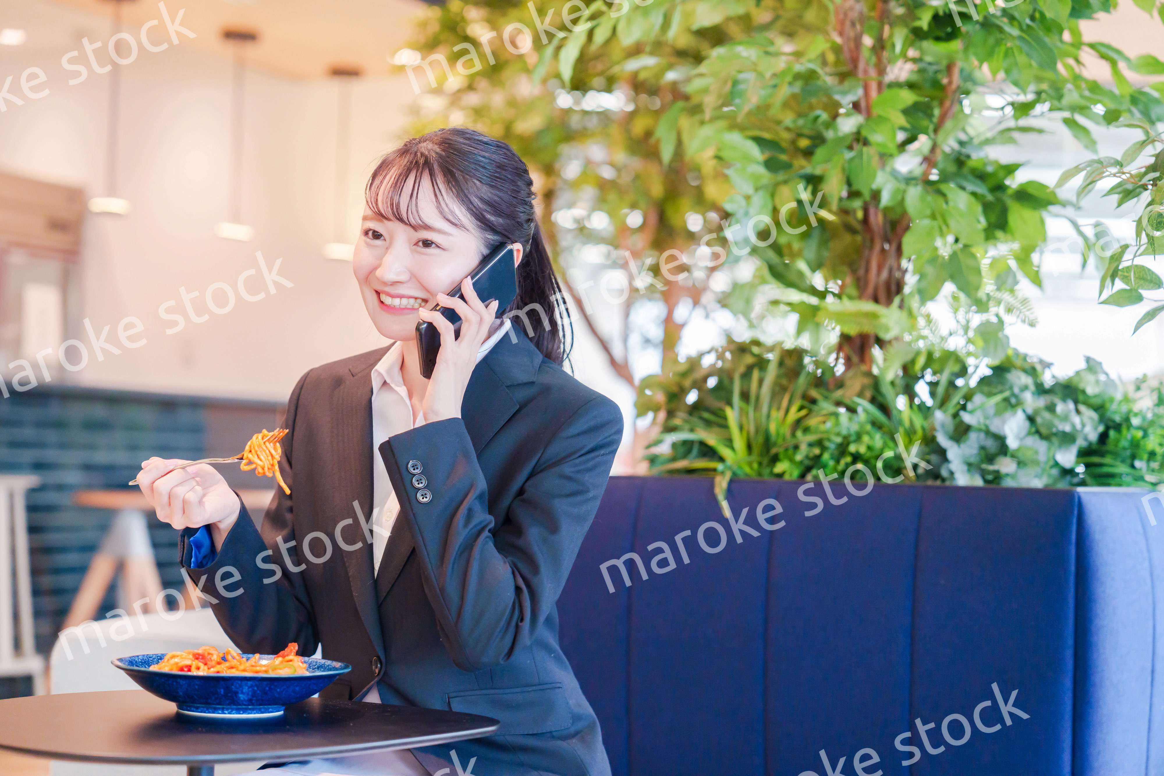 スマホで笑顔で電話をする就活生の女性