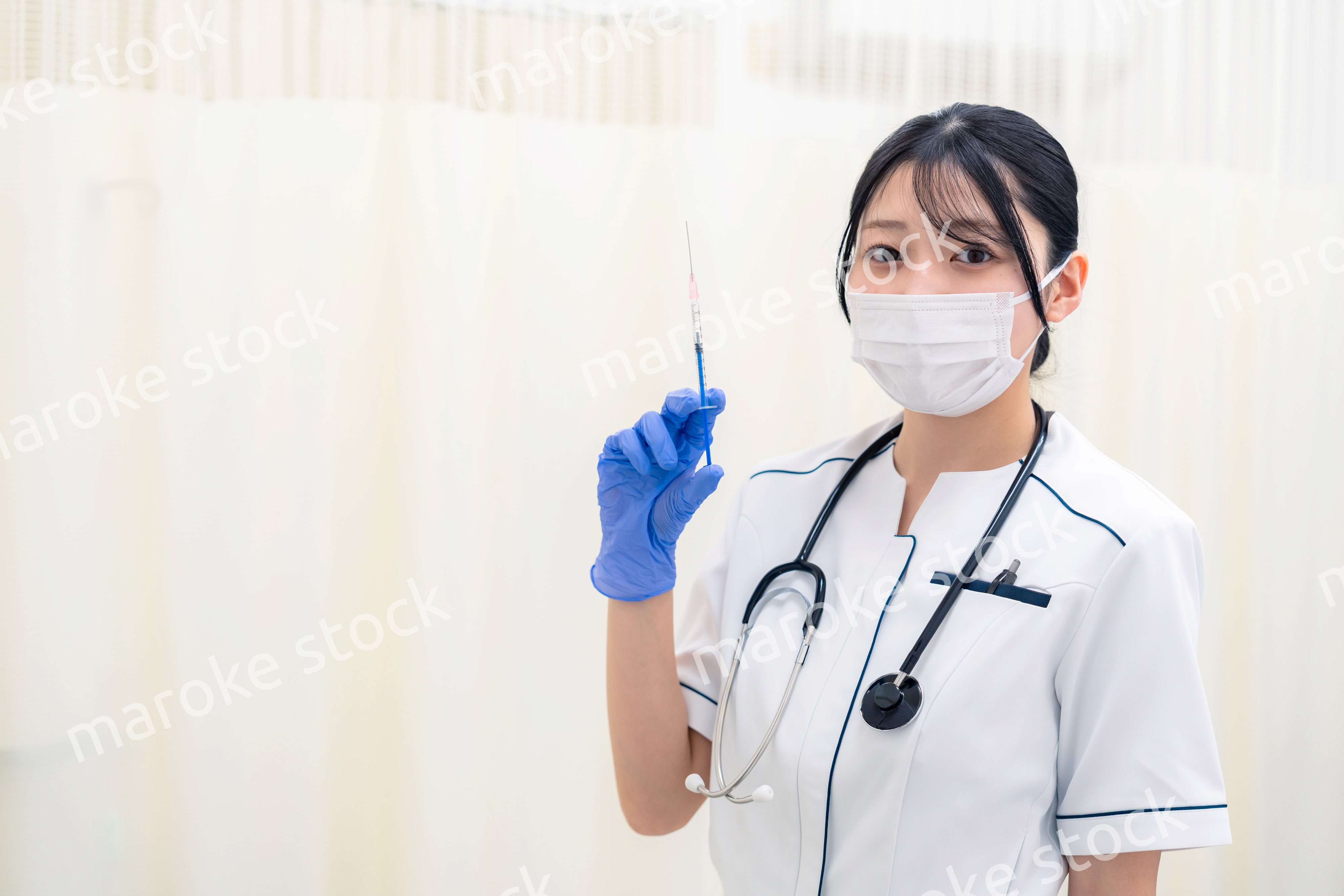 注射器を持つ若い女性の医療従事者