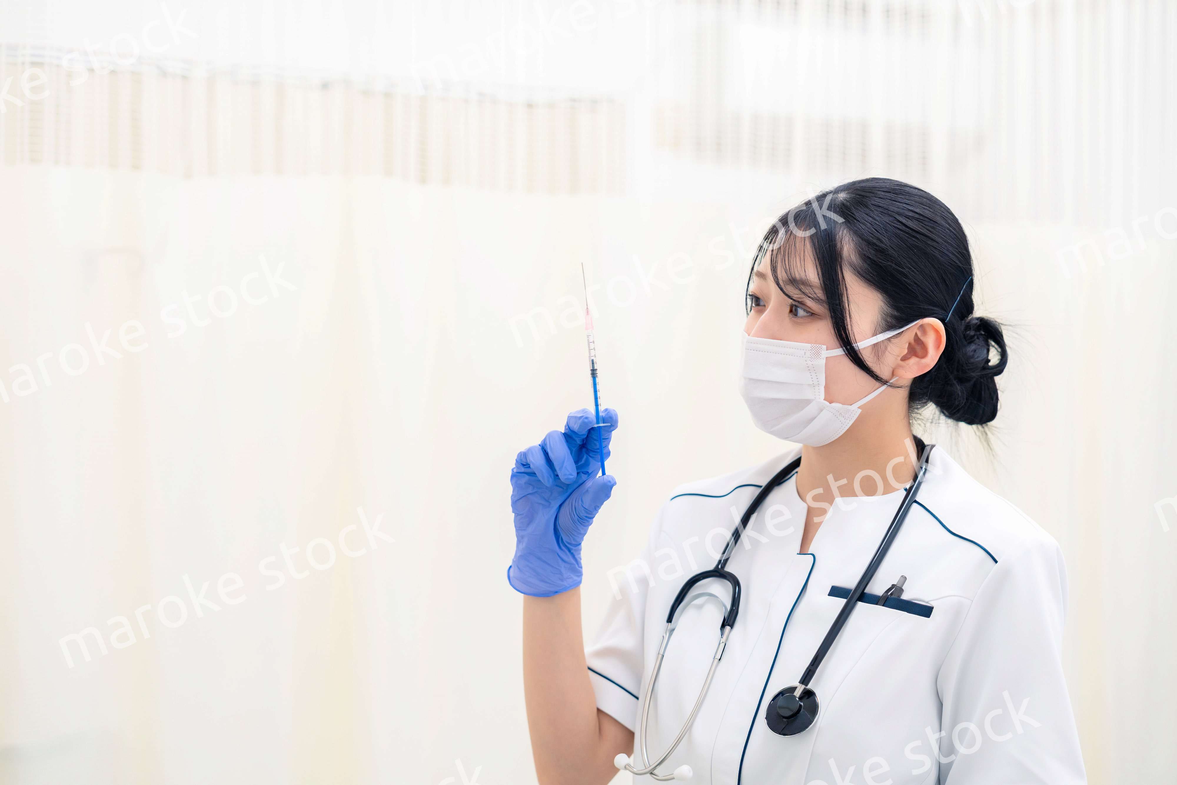 注射器を持つ若い女性の医療従事者