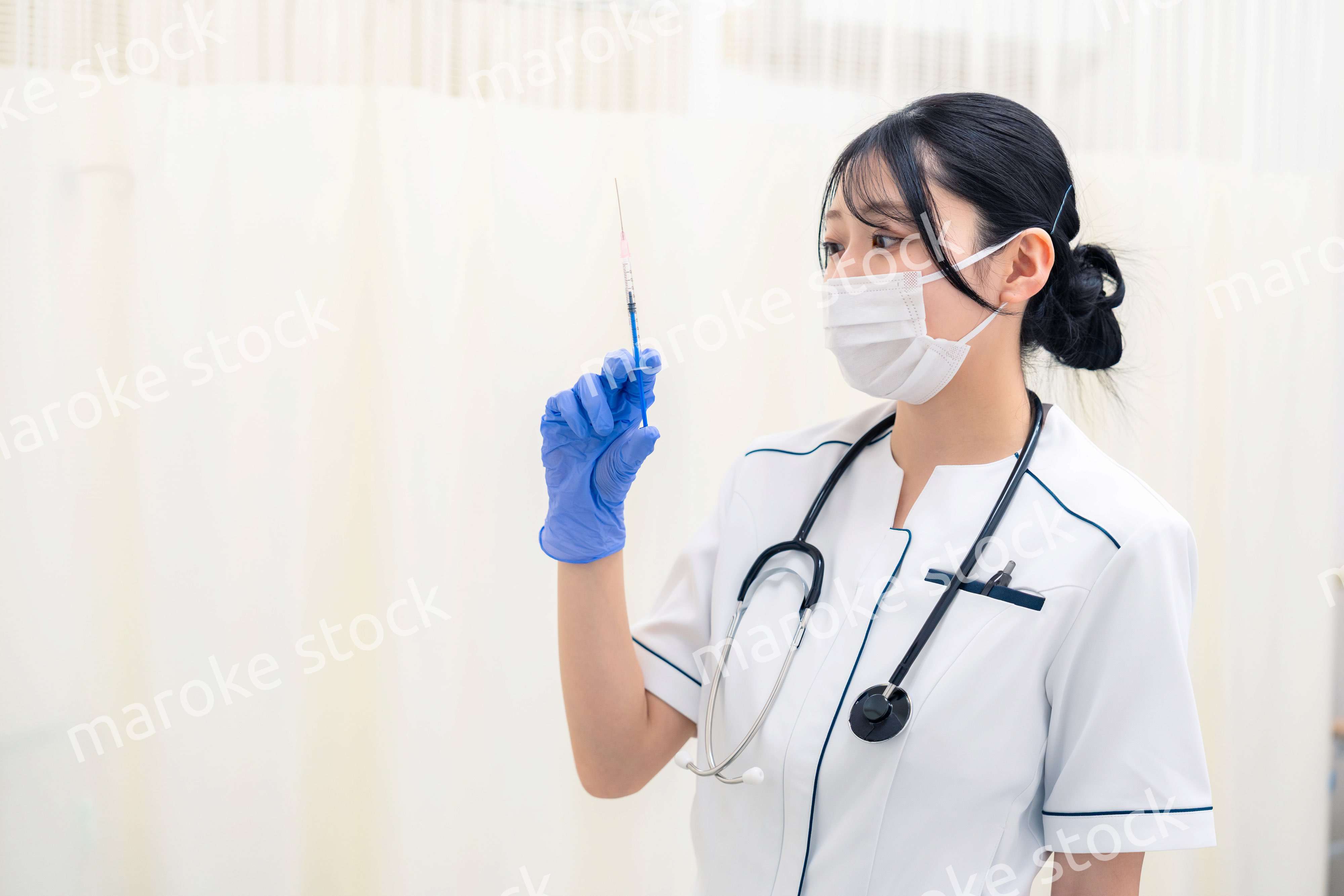 注射器を持つ若い女性の医療従事者