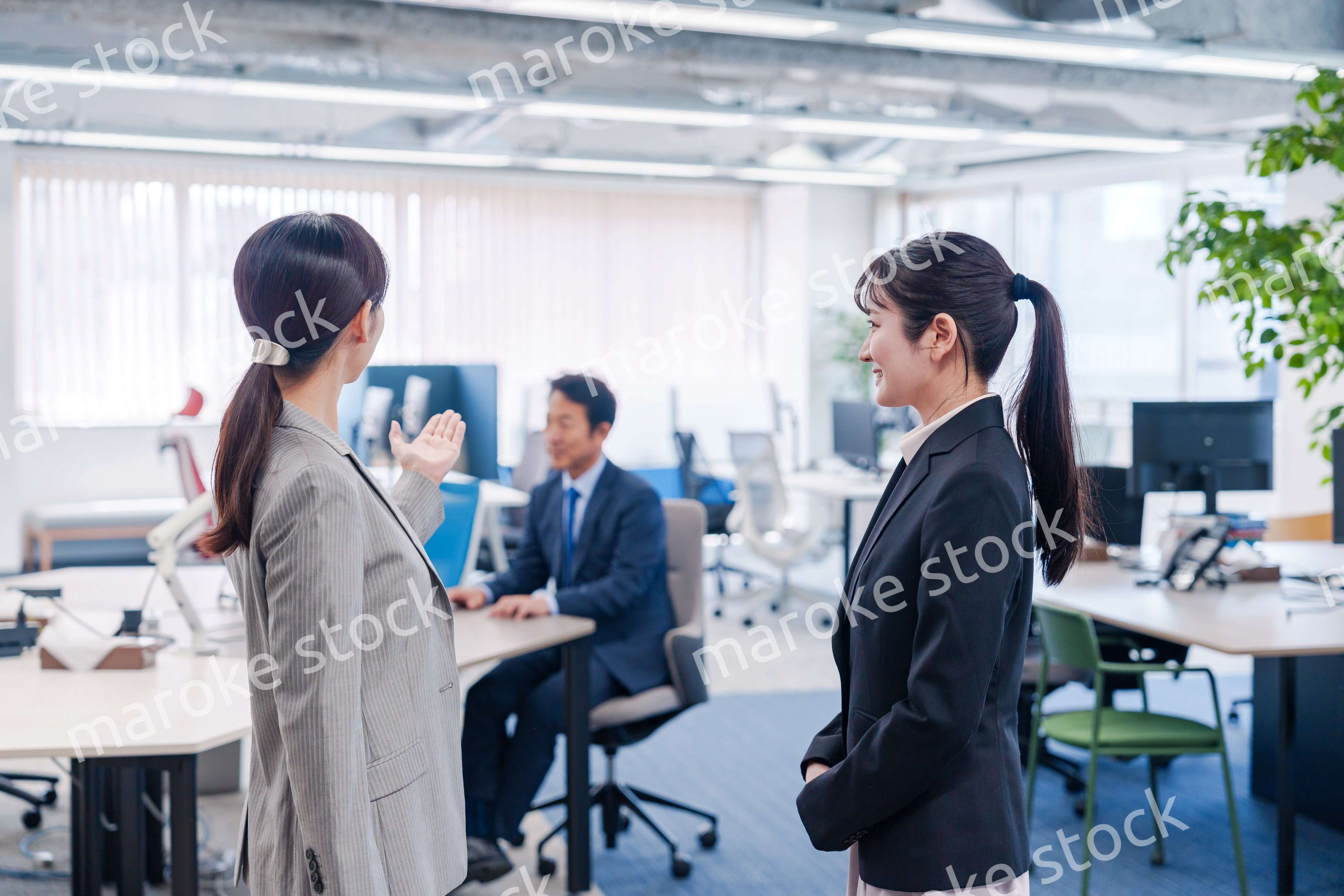 先輩社員にオフィスを案内してもらうフレッシュな女性