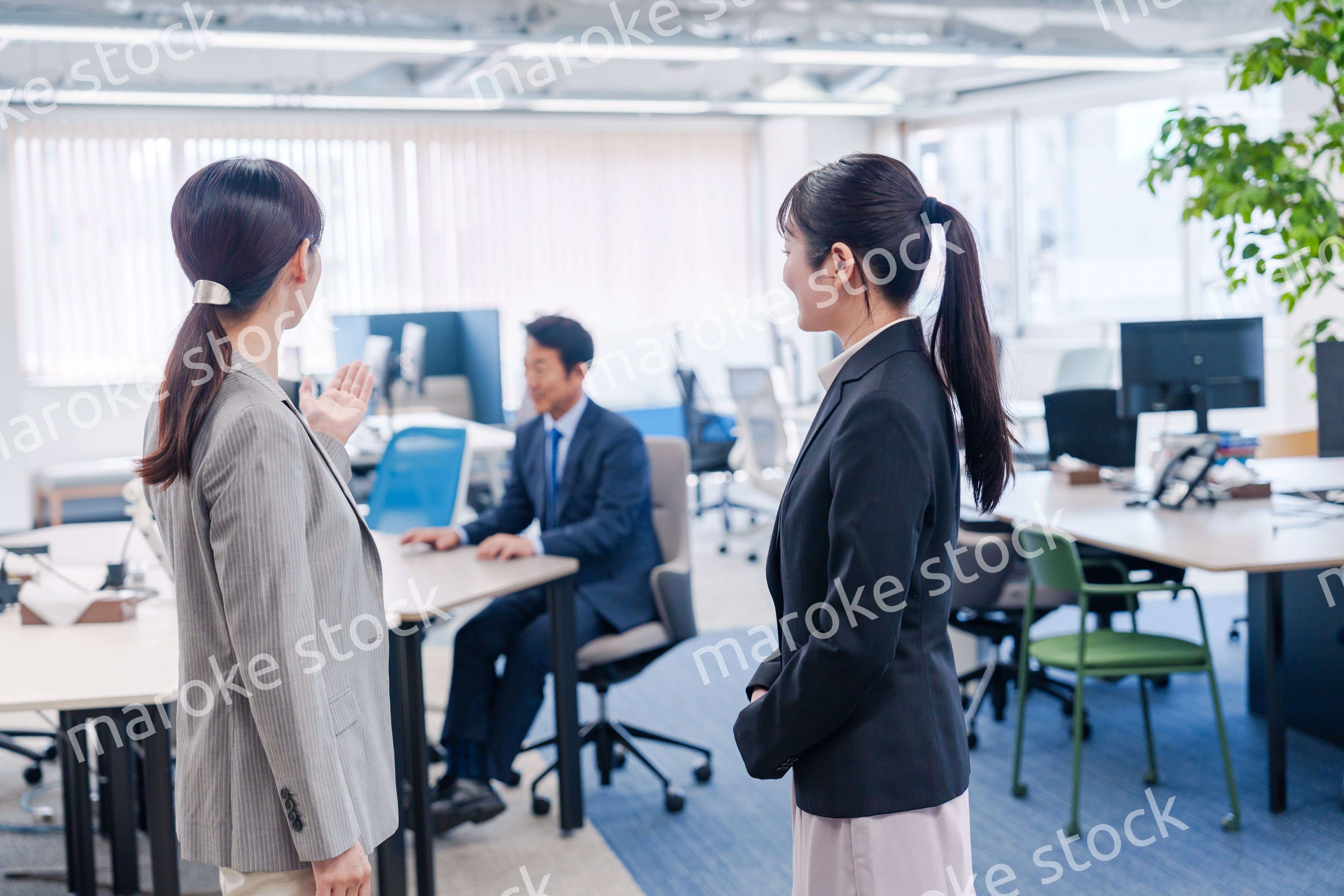 先輩社員にオフィスを案内してもらうフレッシュな女性