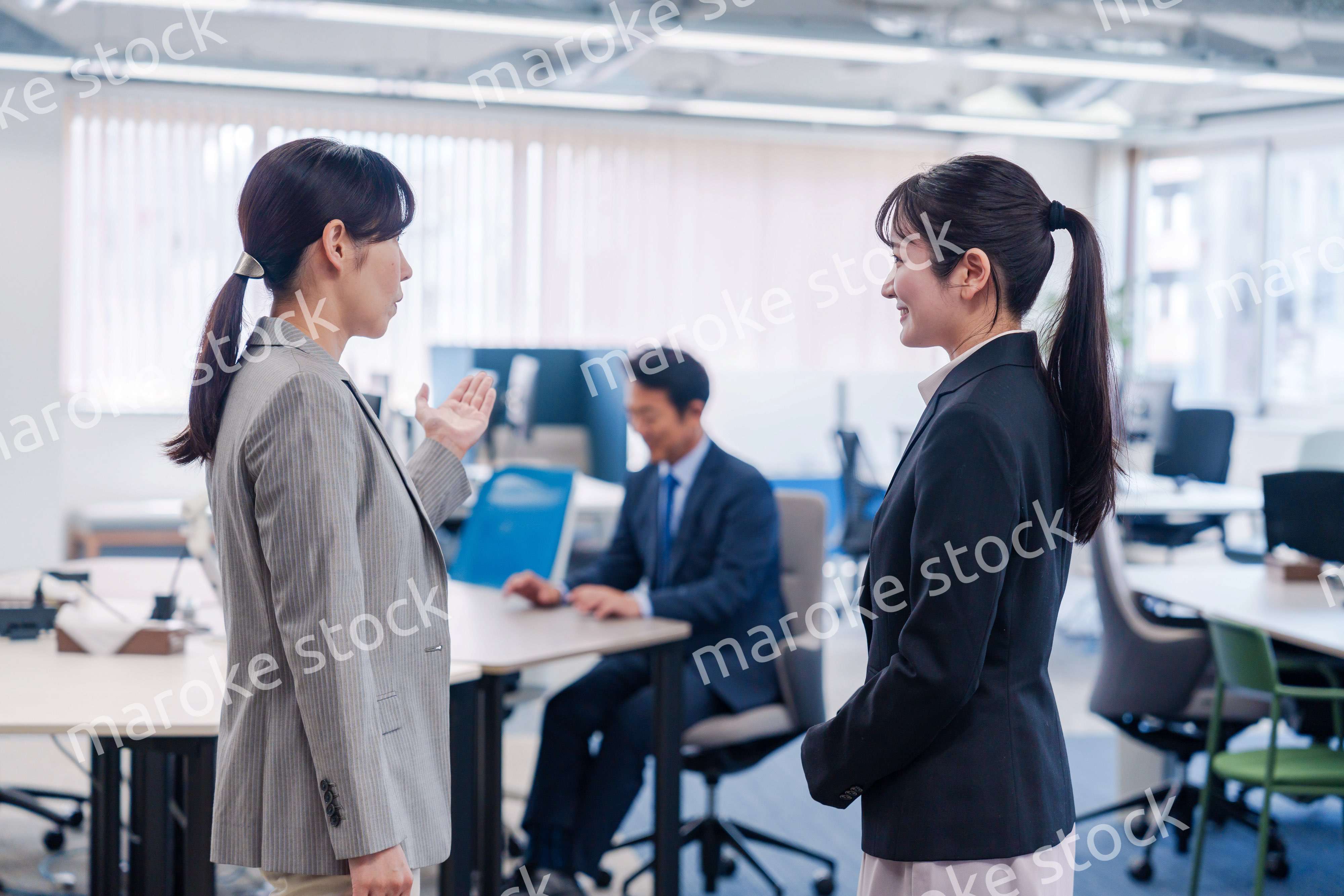 先輩社員にオフィスを案内してもらうフレッシュな女性